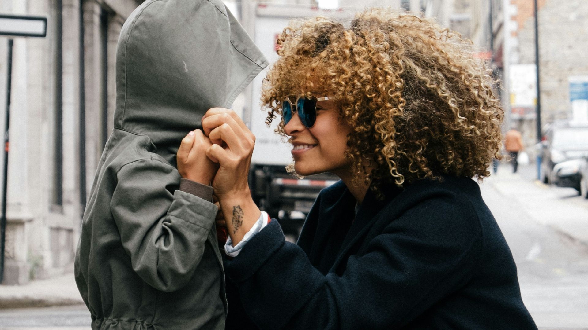 woman holding kid at the street
