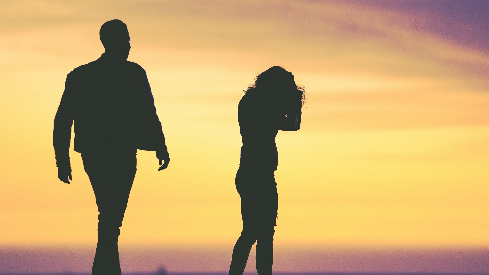 silhouette of man and woman under yellow sky