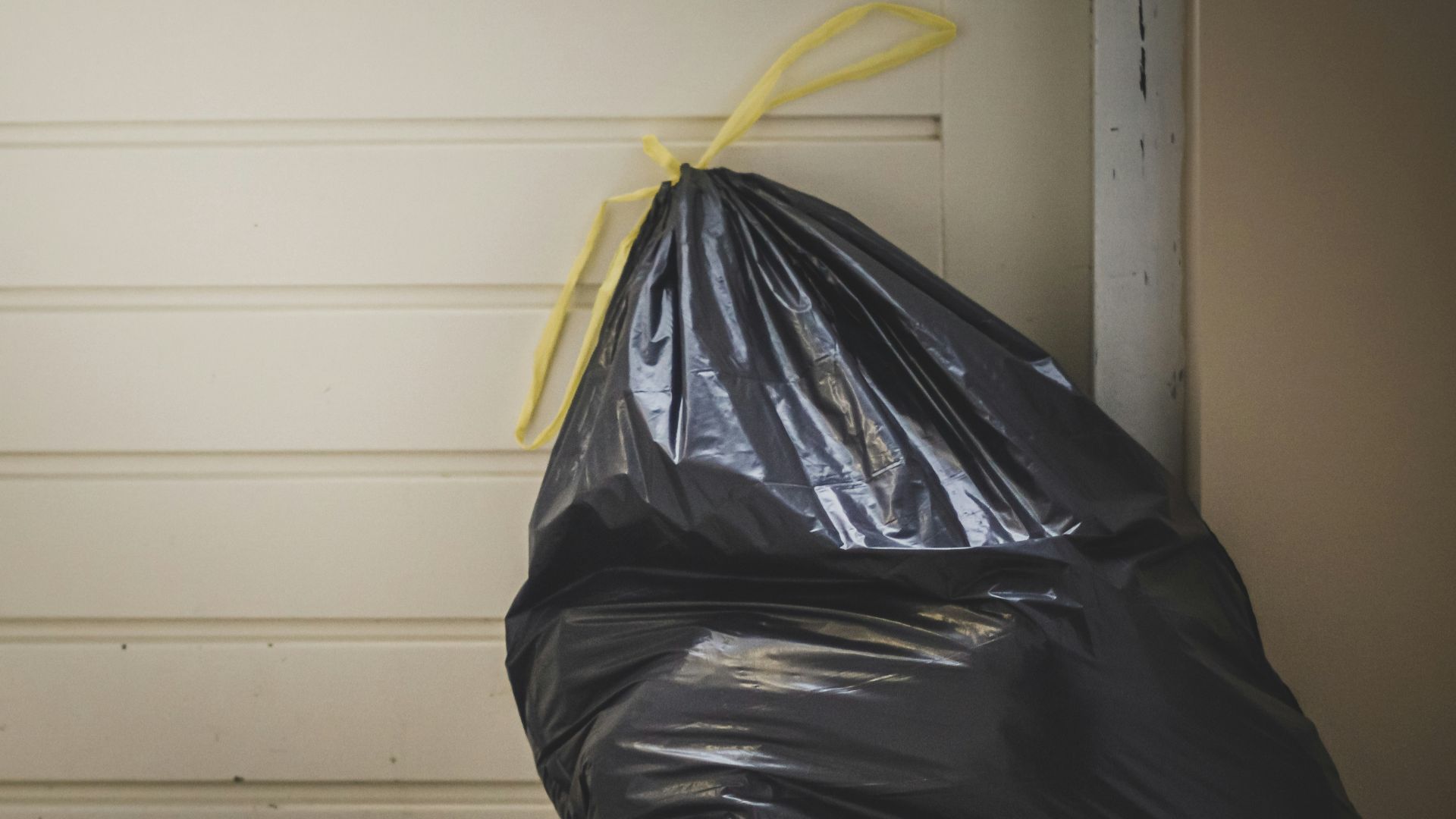 black plastic bag beside white wall