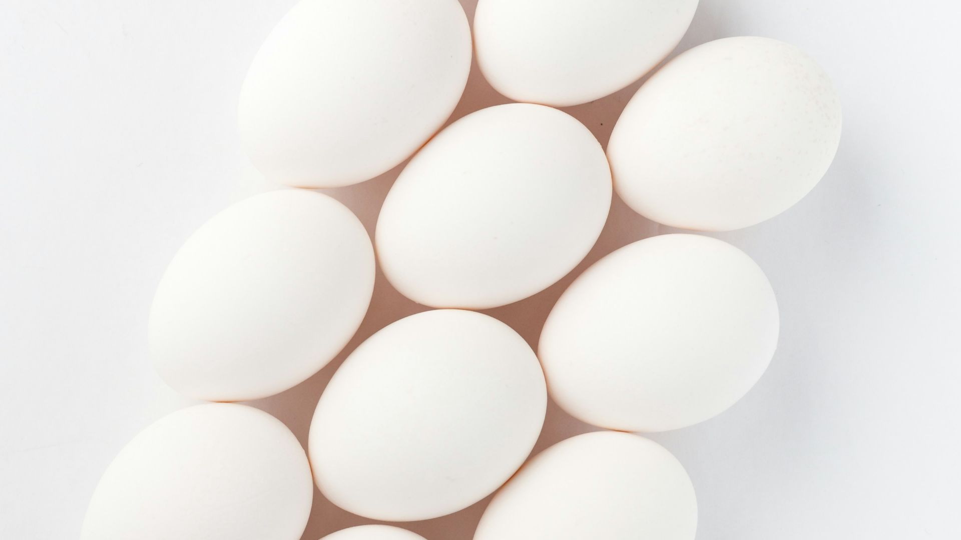 twelve white eggs on white surface