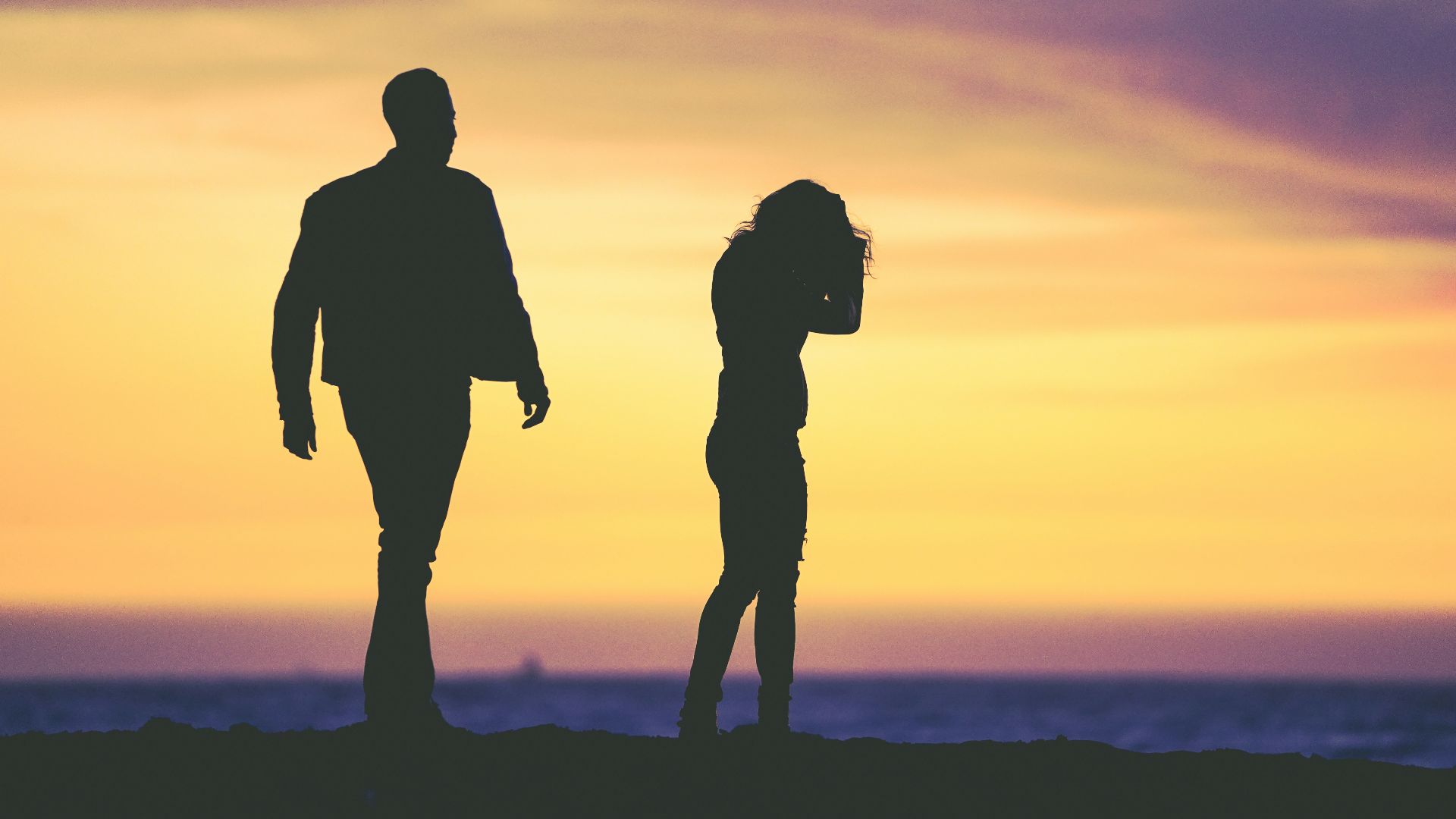 silhouette of man and woman under yellow sky