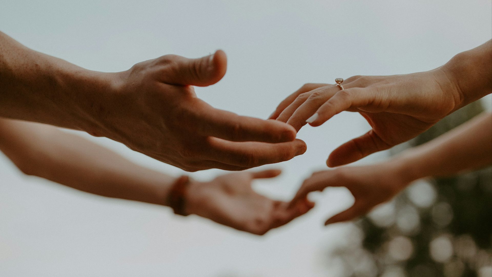 a group of people reaching out their hands