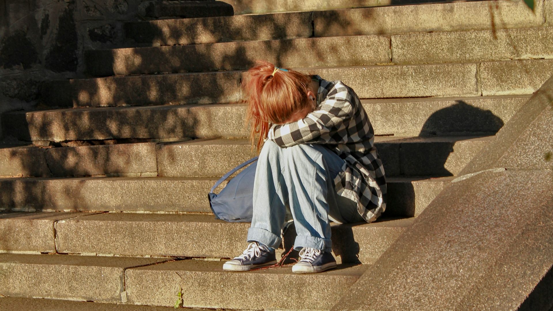woman in black and white dress sitting on concrete stairs