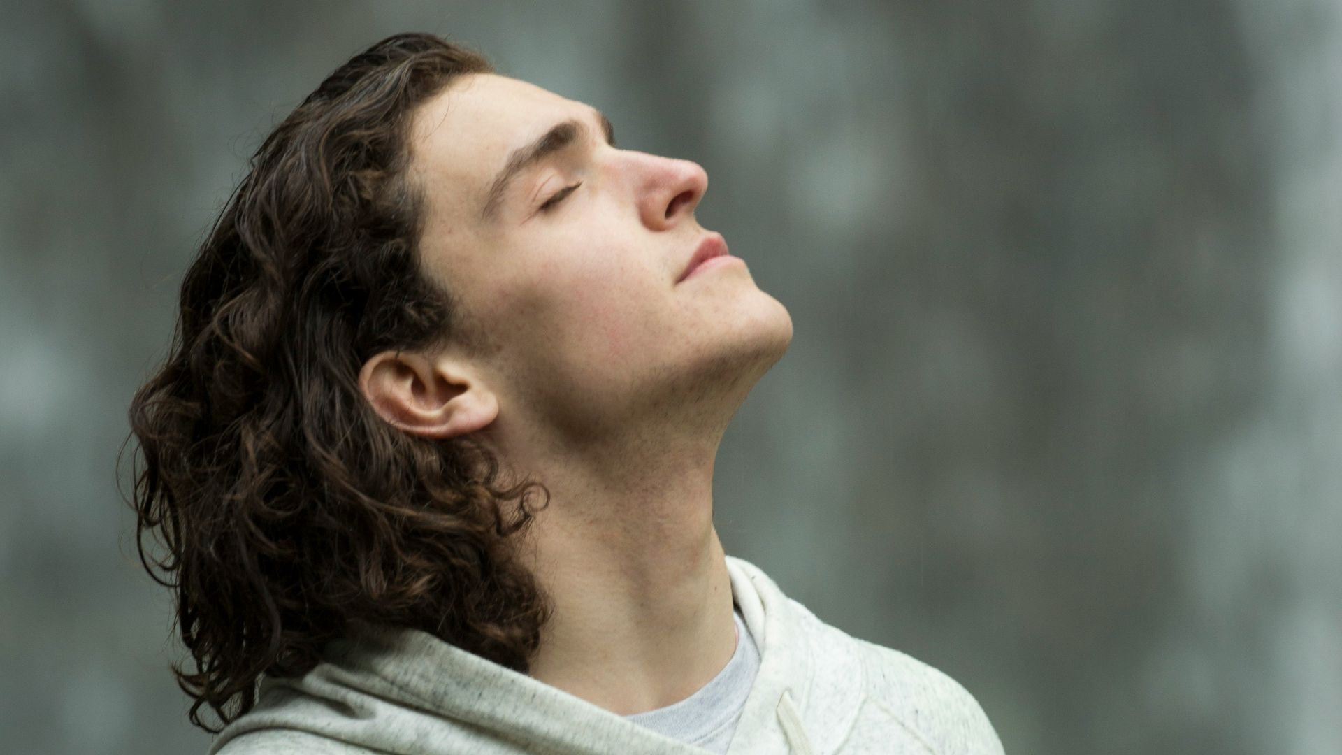 man in gray pullover hoodie closed eyes while heads up