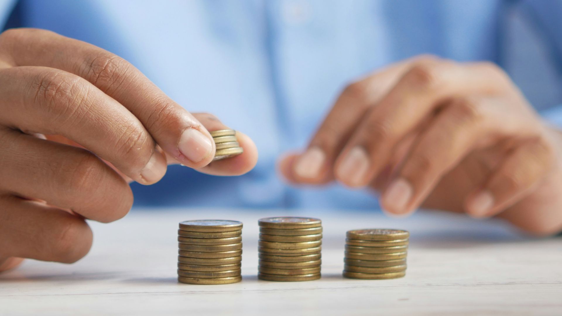a person stacking coins on top of a table
