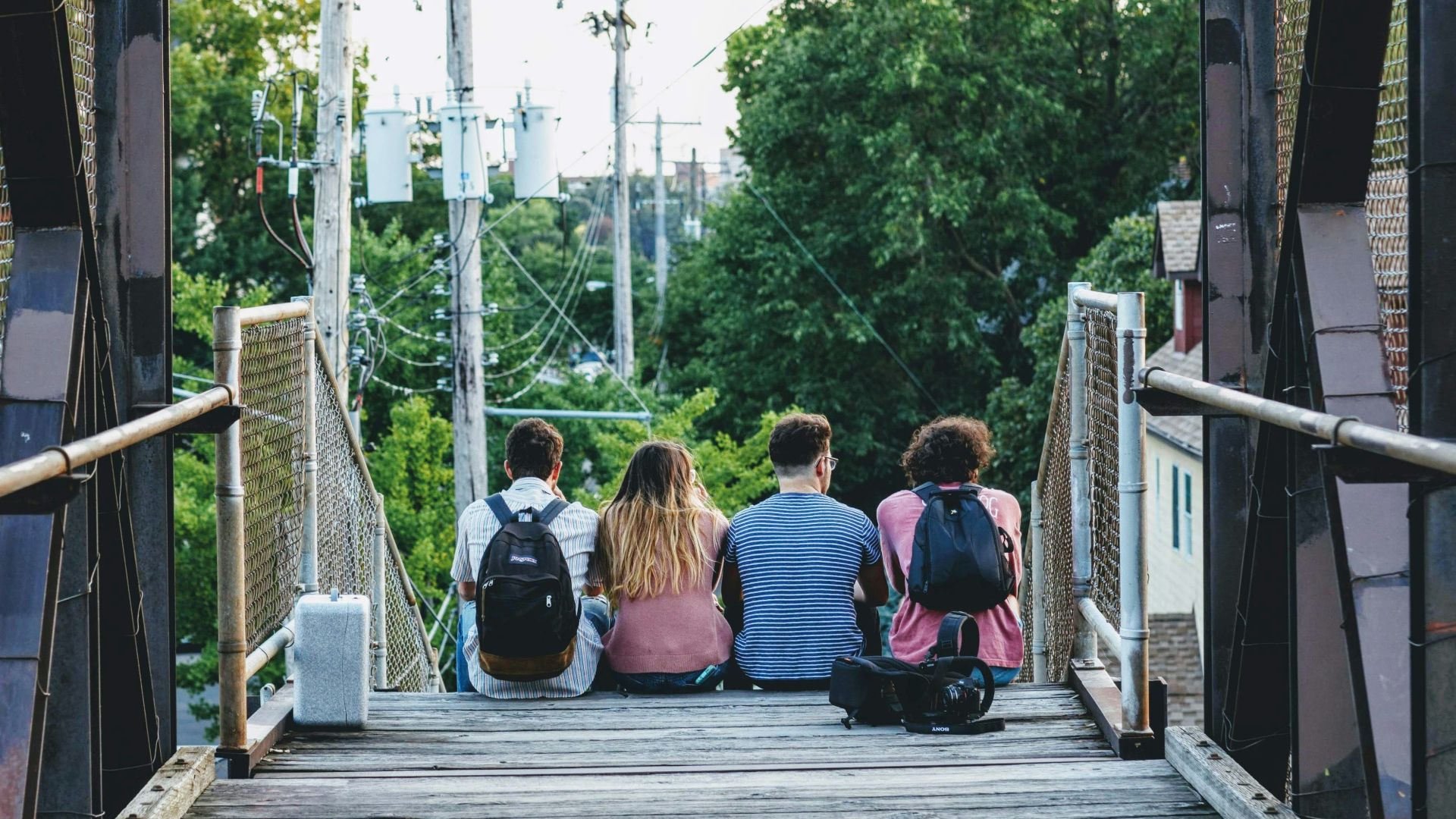 a group of people sitting on a bridge