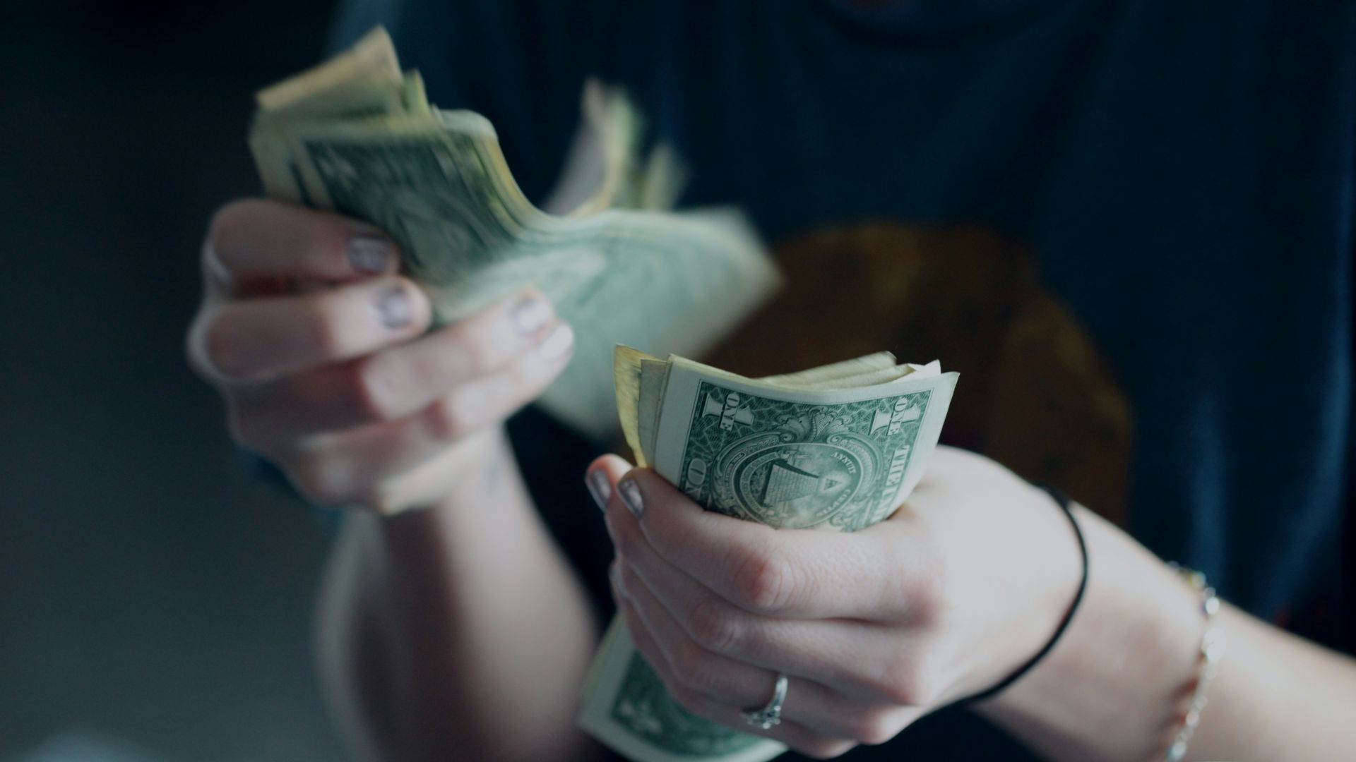 focus photography of person counting dollar banknotes