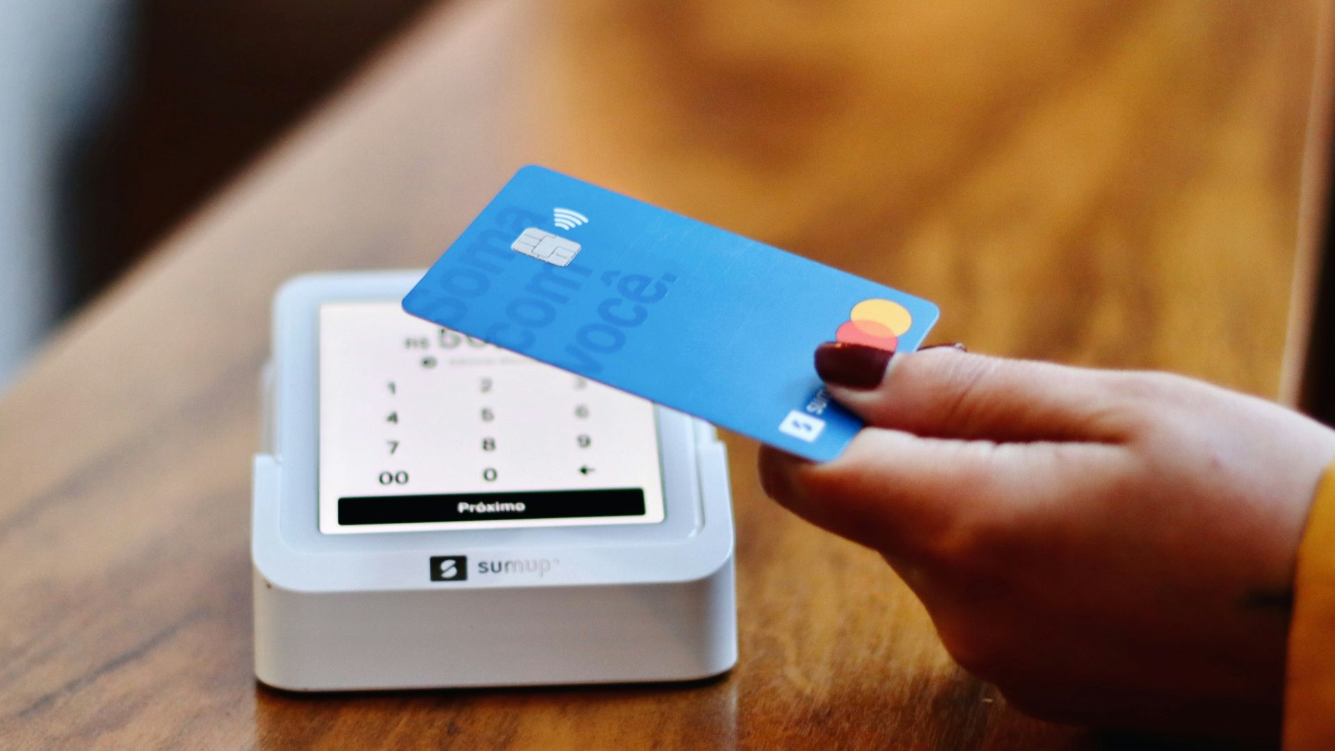 a person holding a credit card in front of a machine