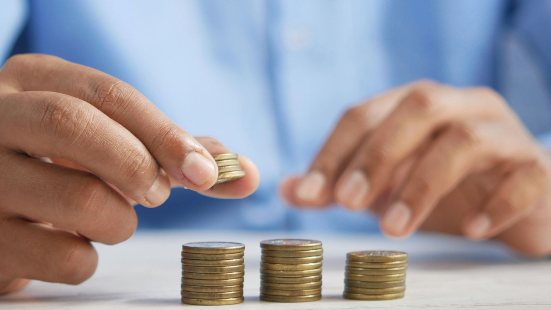 a person stacking coins on top of a table