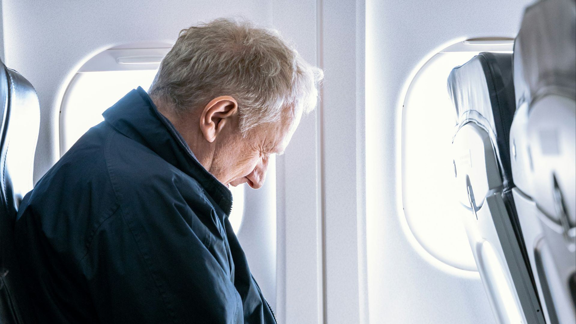 a man reading a book on an airplane
