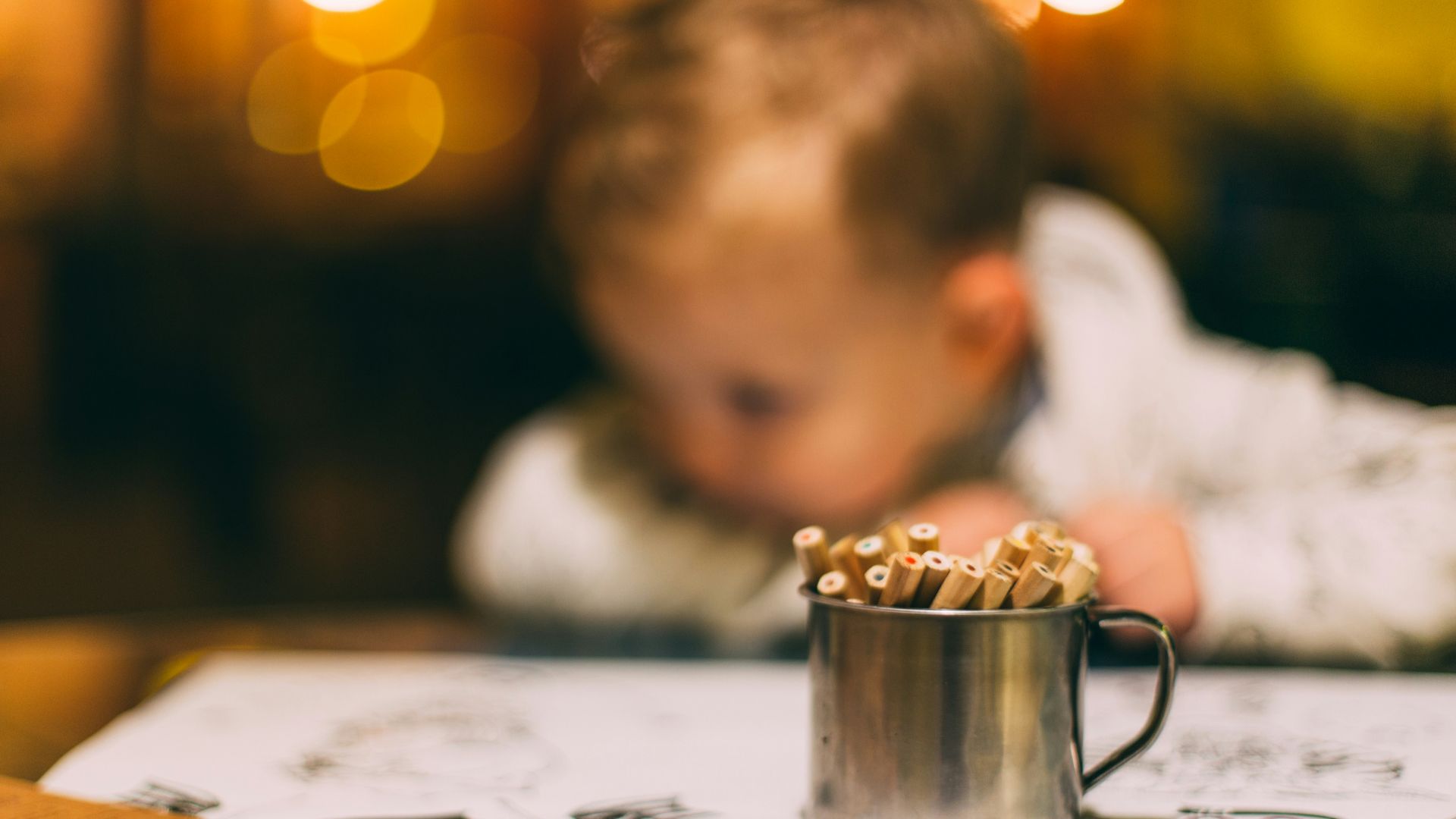selective focus photography of colored pencils in mug