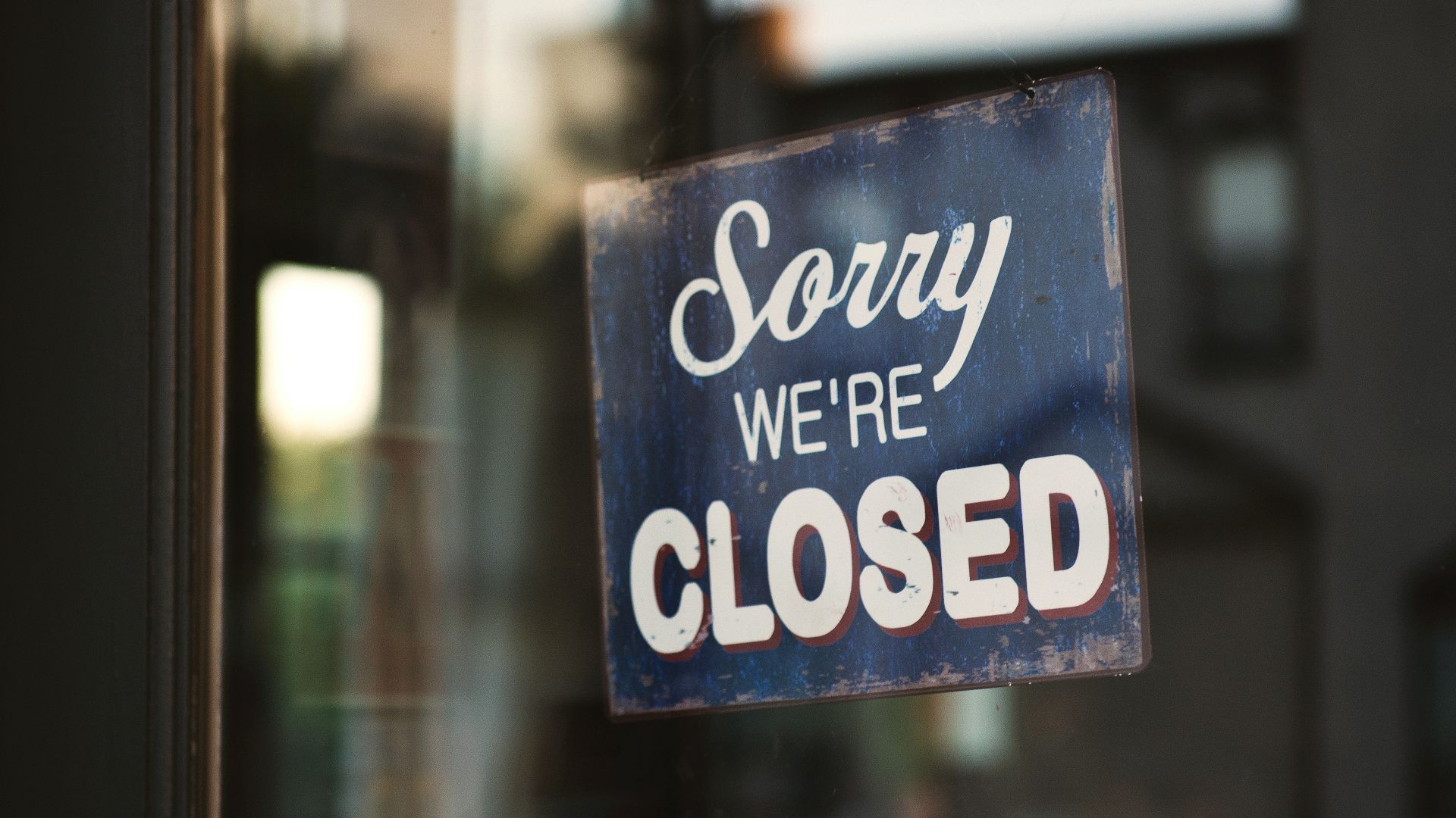 Sorry we're closed signage hanged on glass door