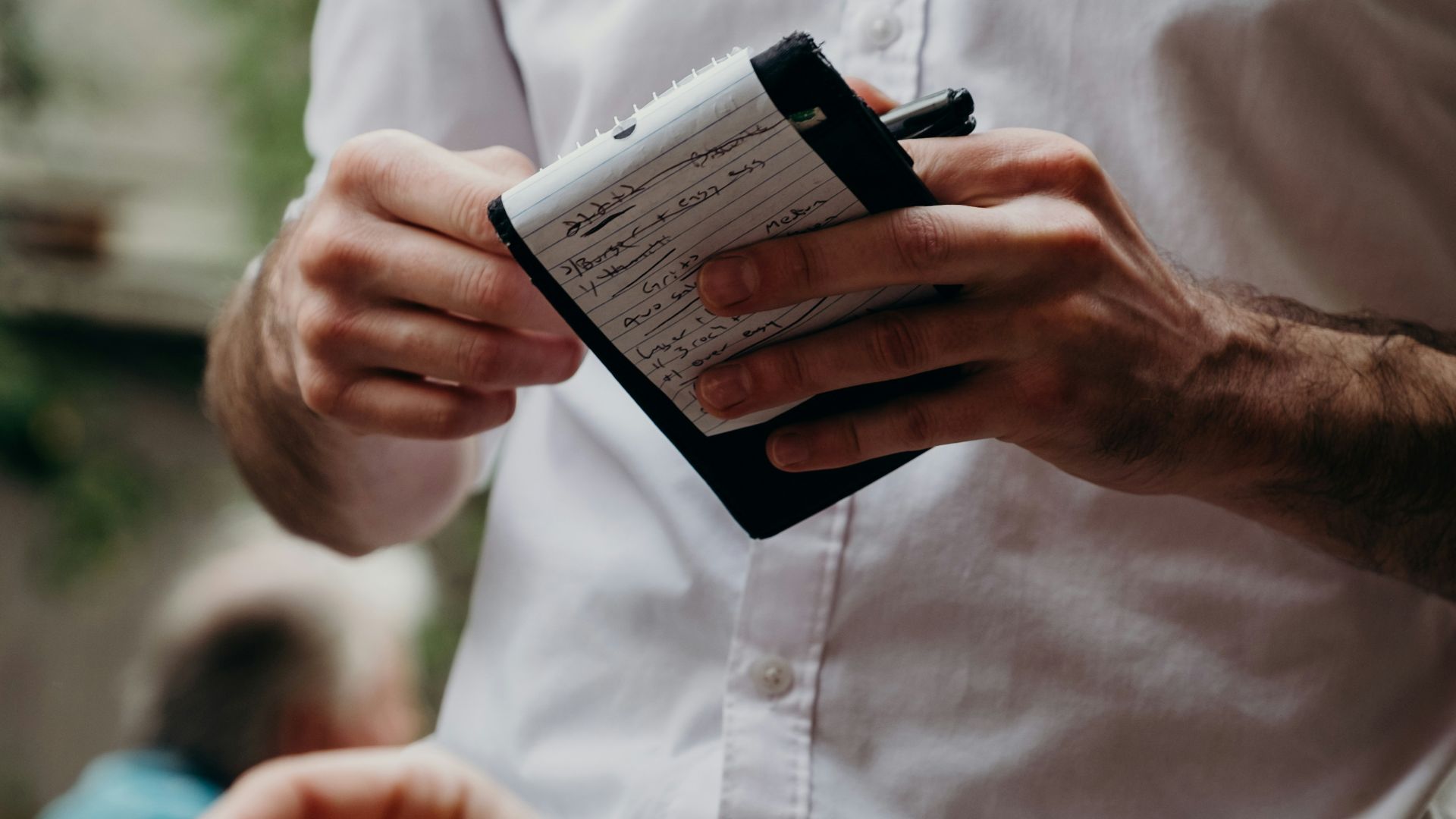 man in white button up shirt holding black and white box