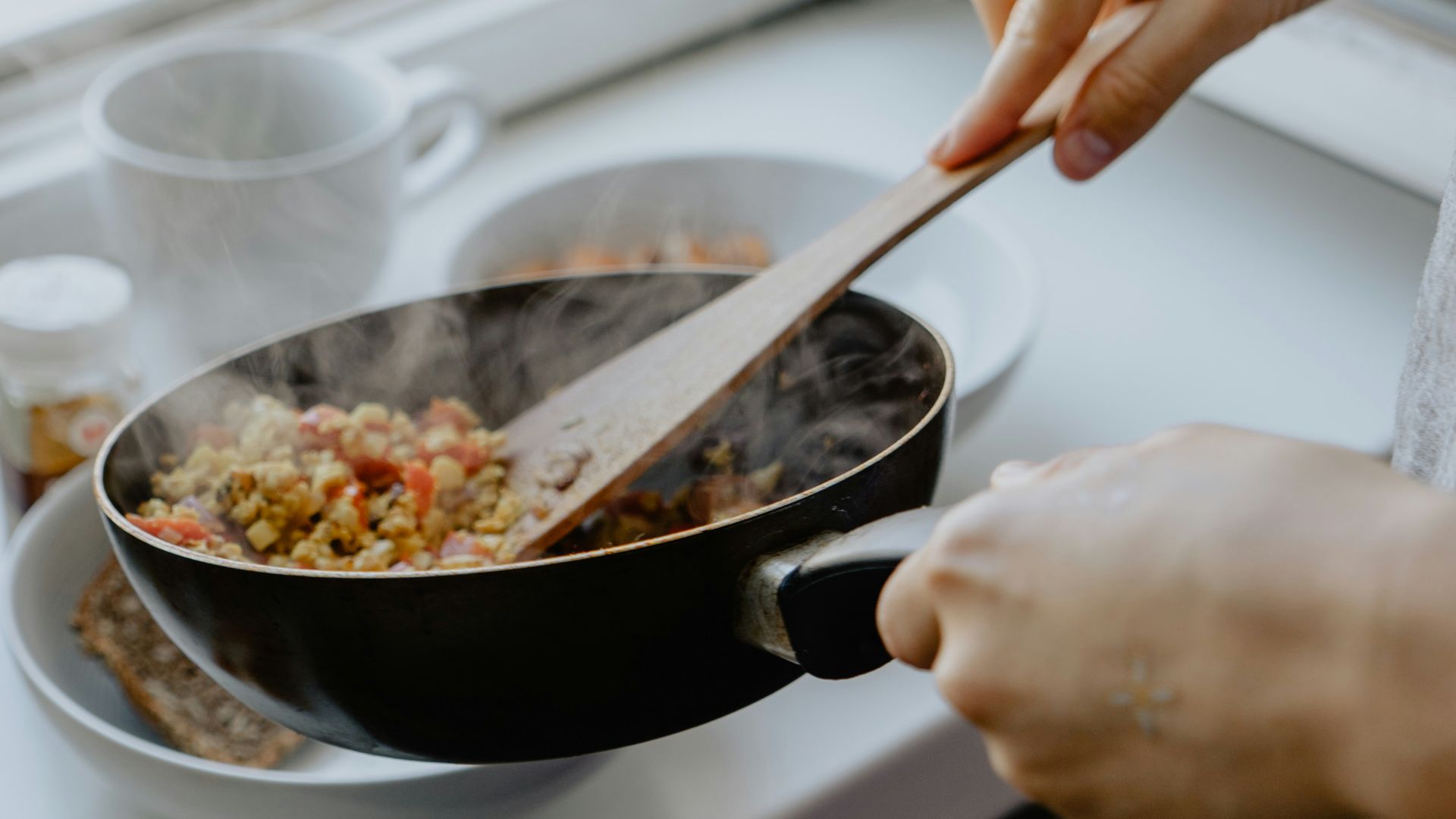 person holding black frying pan
