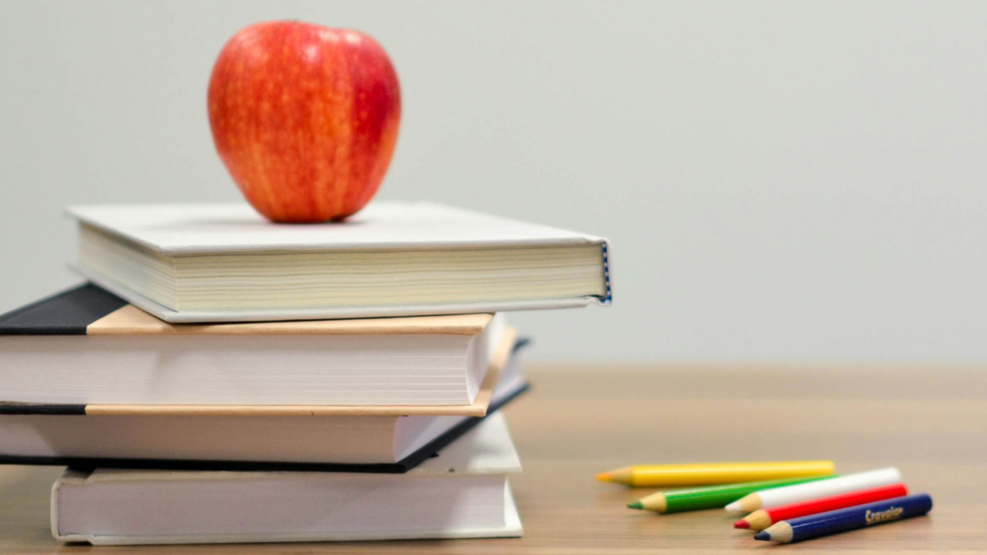 red apple fruit on four pyle books