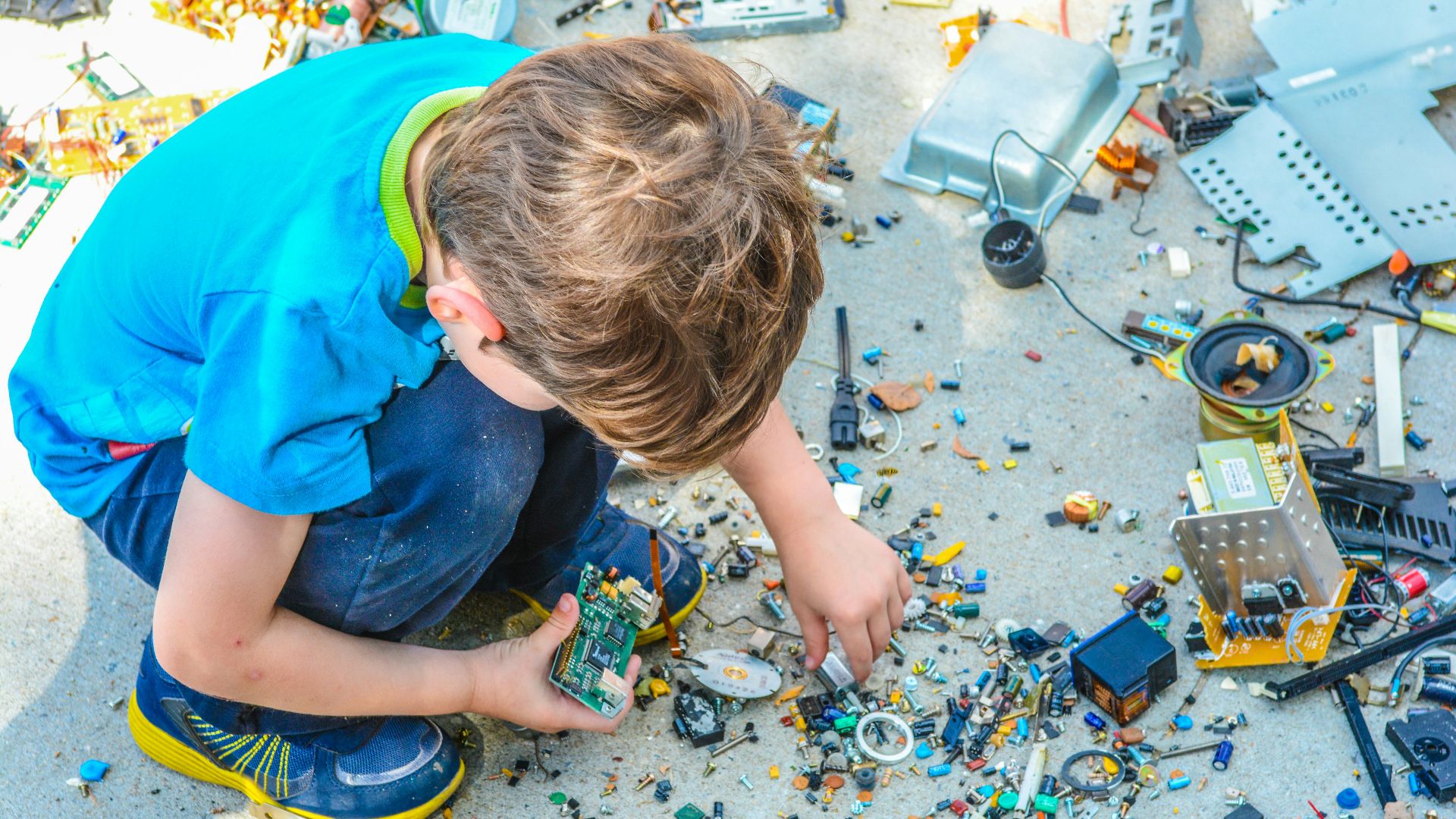 boy sitting while holding electronic device part