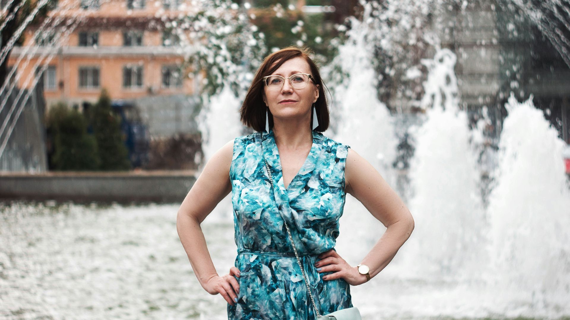 woman in blue and white floral sleeveless dress standing on snow covered ground during daytime