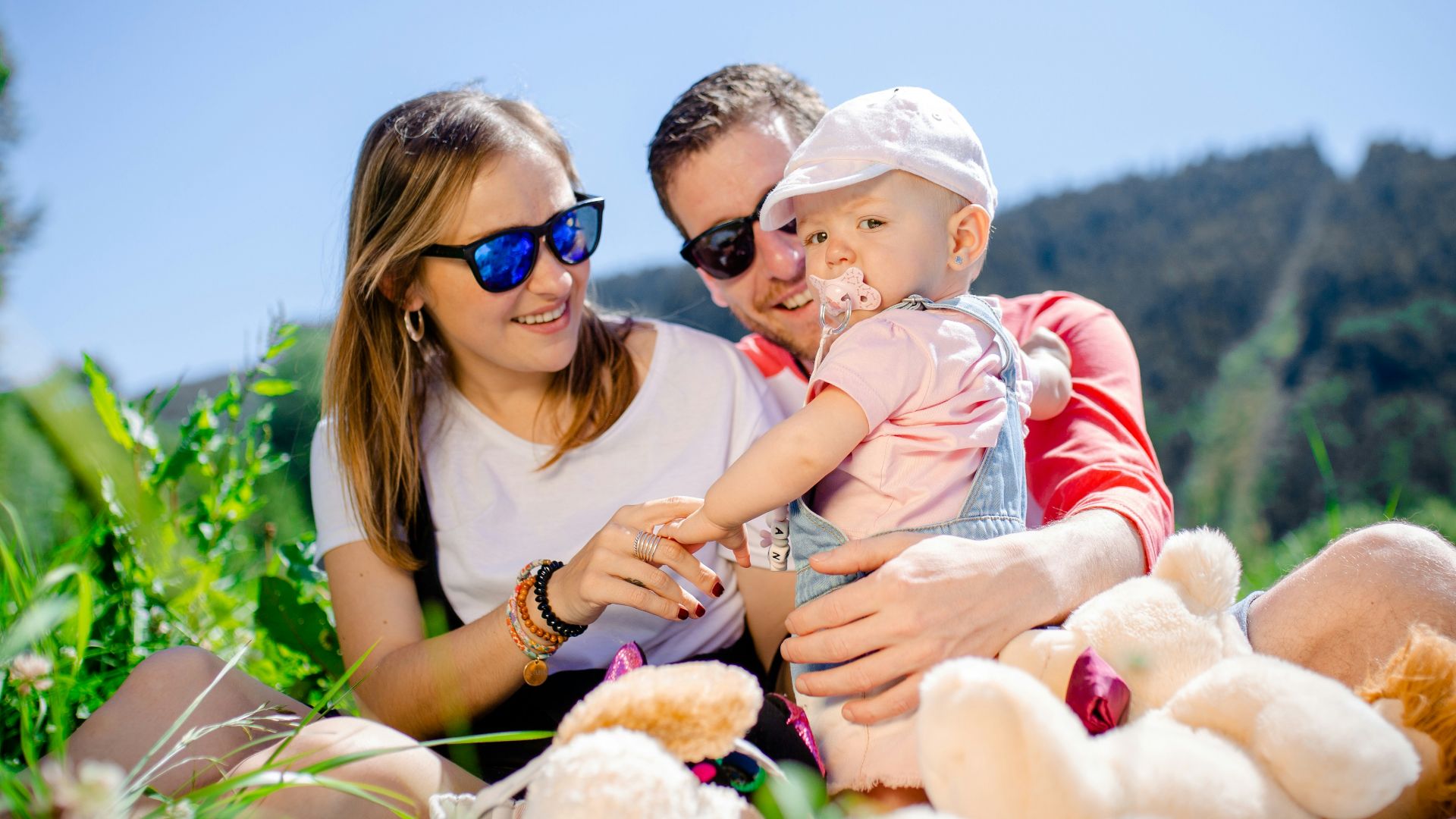 woman in white shirt carrying baby in white and red stripe shirt