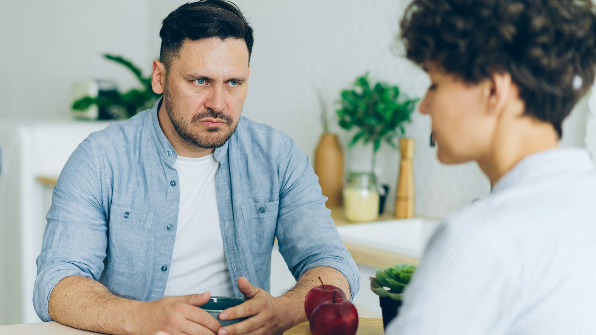 a man sitting at a table talking to a woman