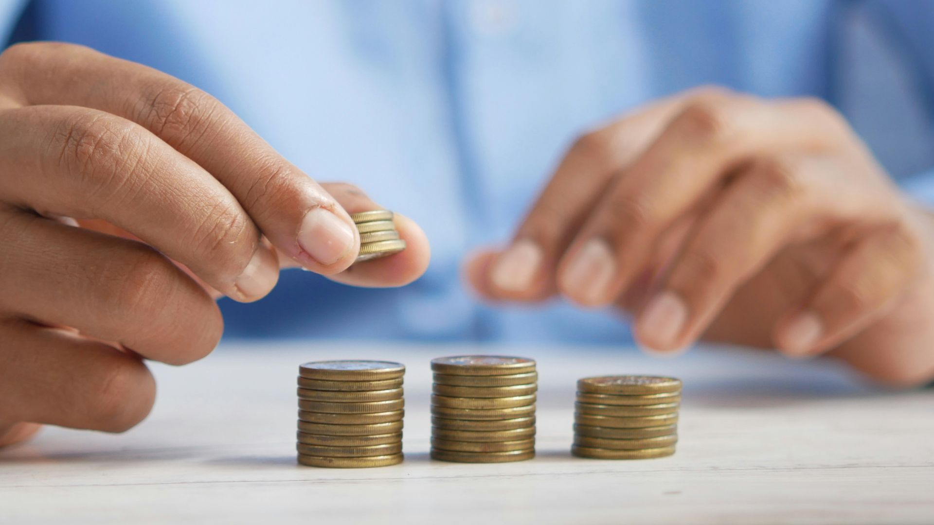a person stacking coins on top of a table