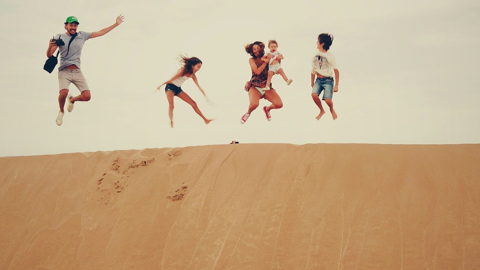 people jumping on sand