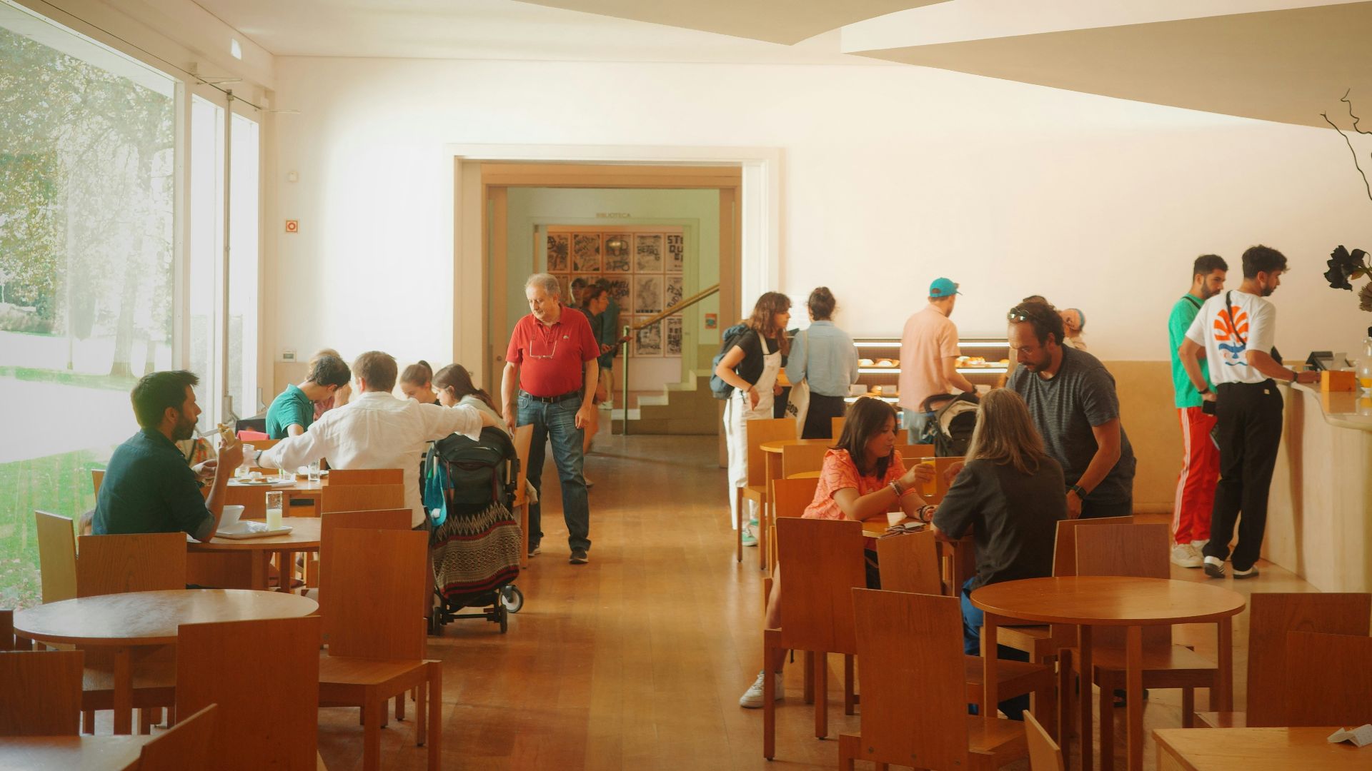 People are eating and socializing in a bright dining area.