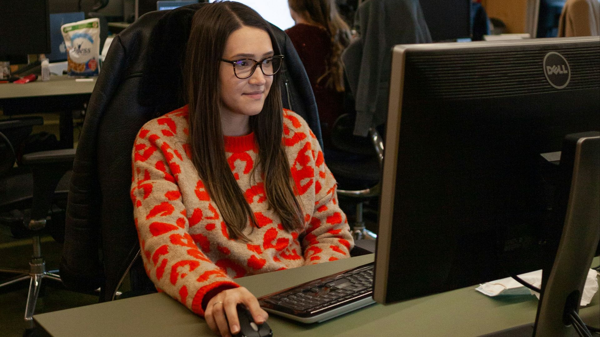 a woman sitting at a desk in front of a computer