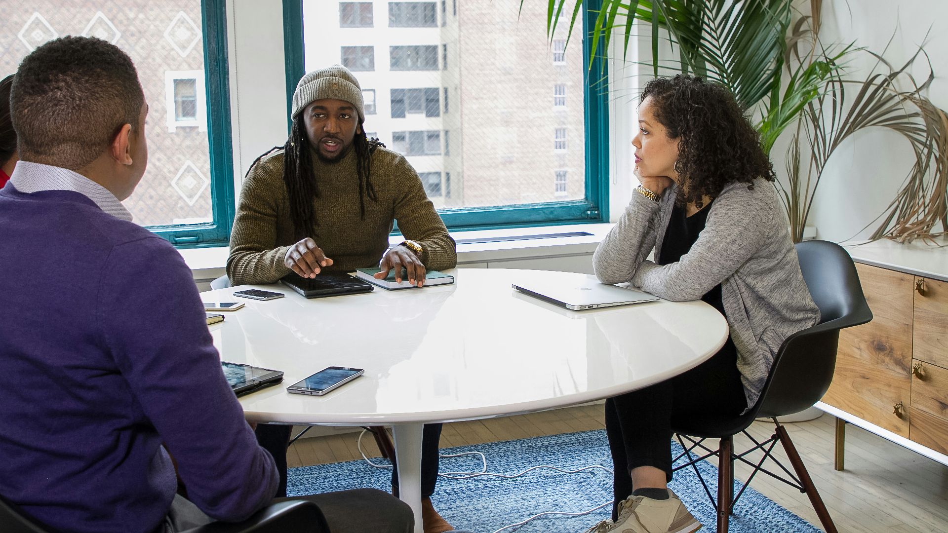 a group of people sitting around a white table