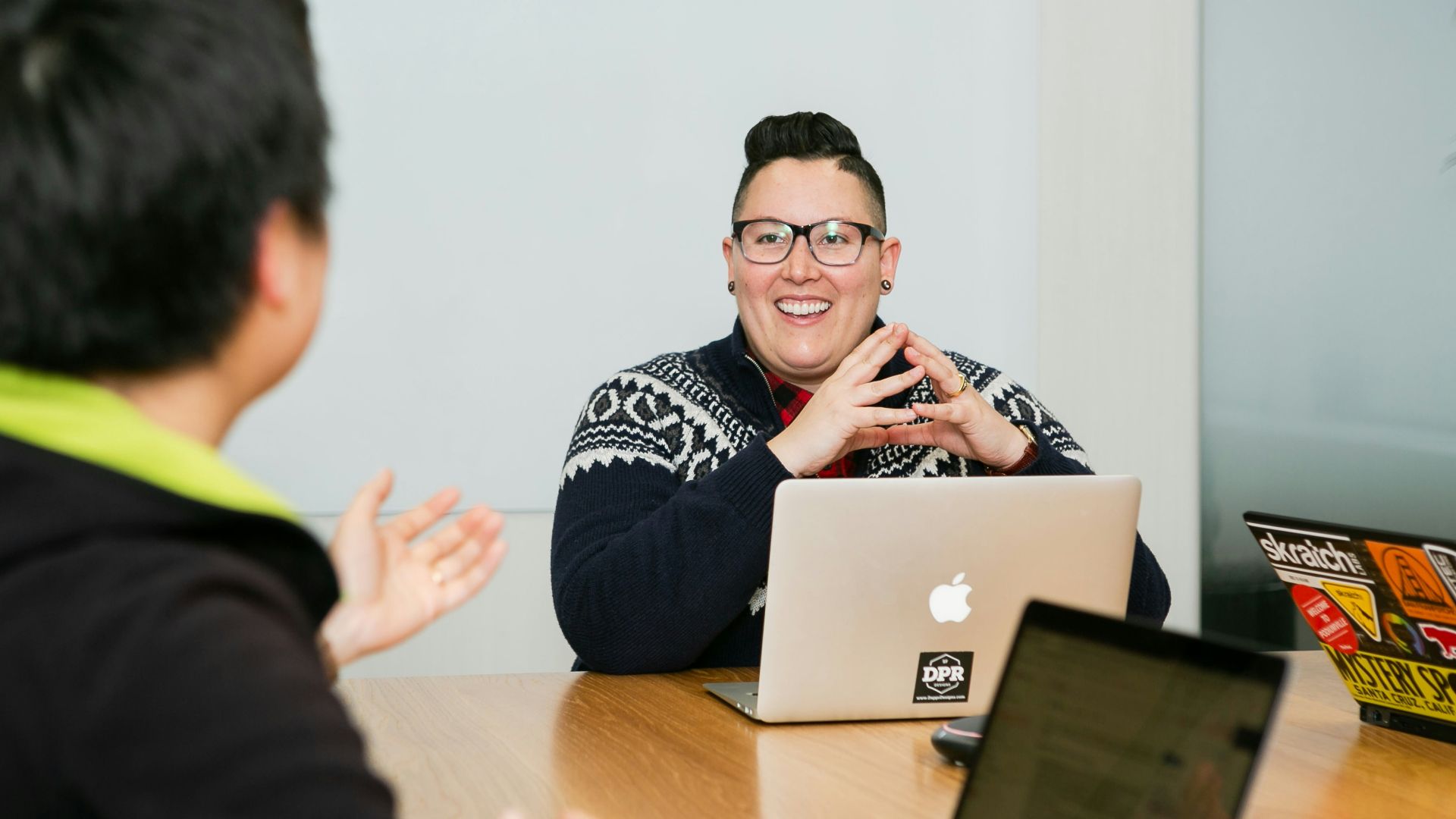 people in a meeting with laptops in front of them