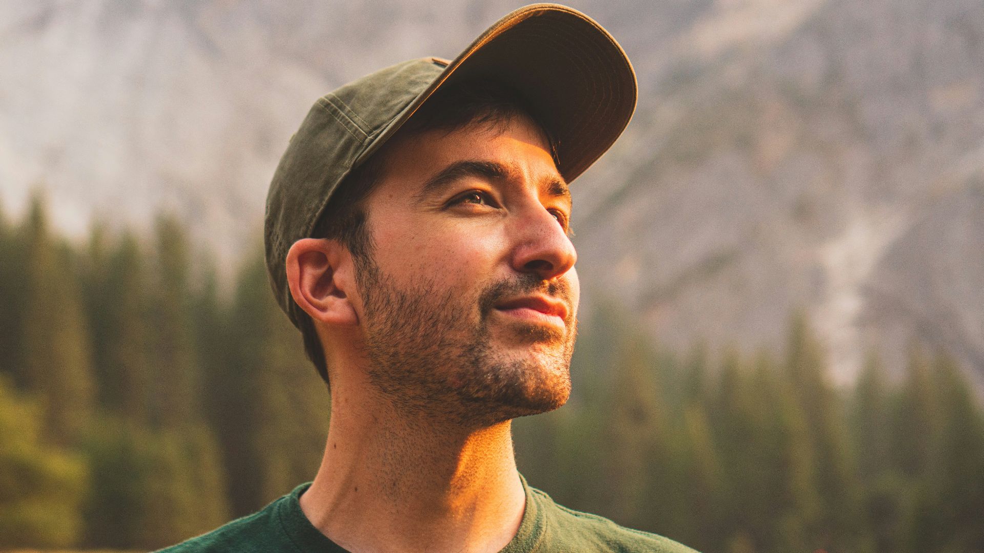 man in green crew neck shirt and black hat