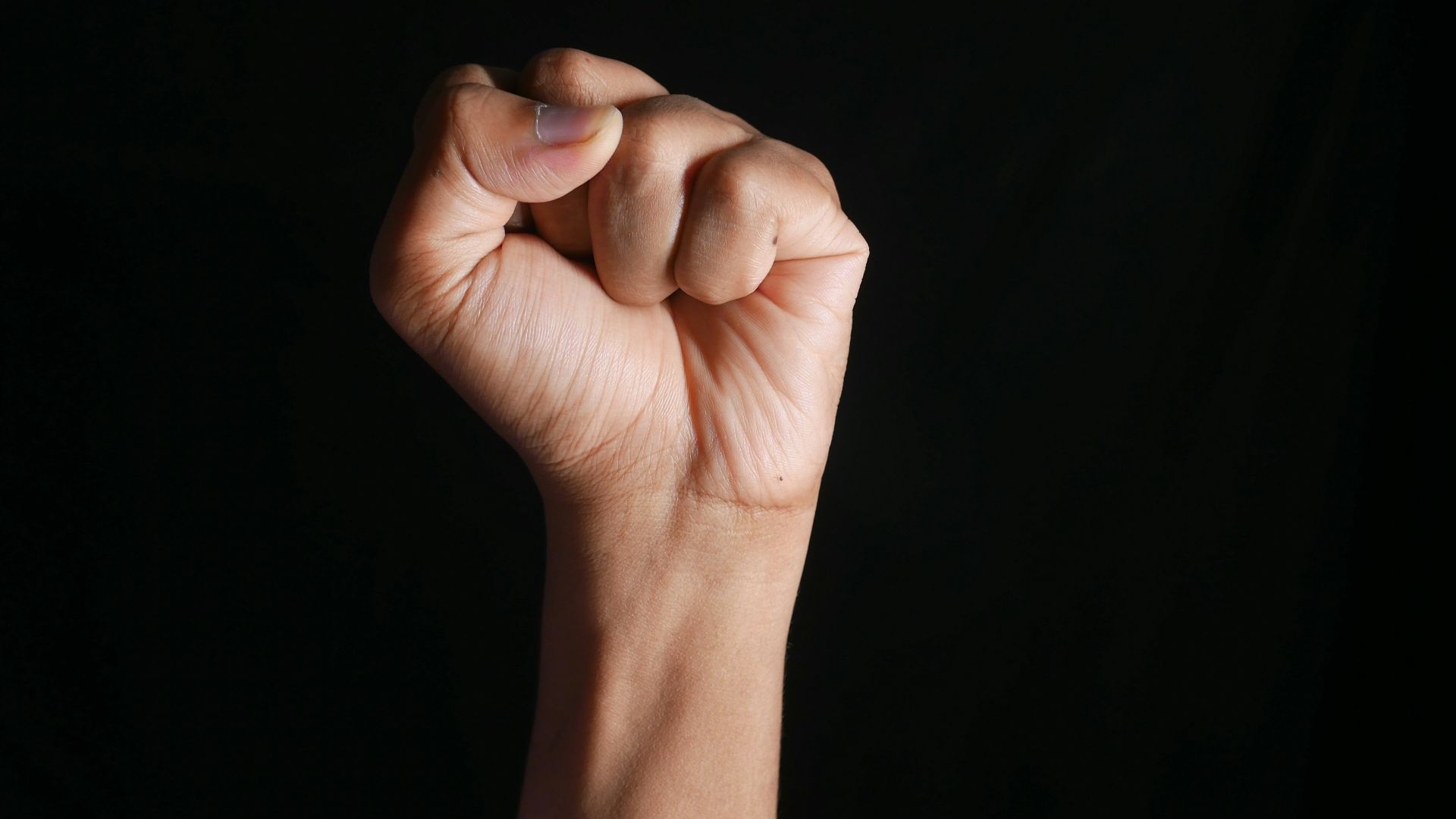 persons right hand doing fist gesture