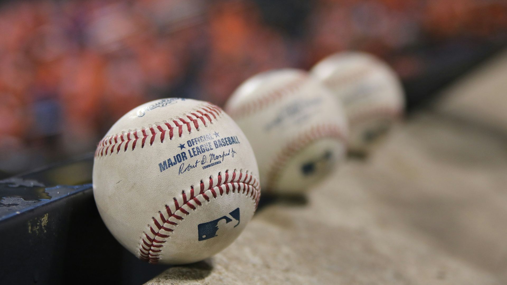 three white baseballs on gray textile