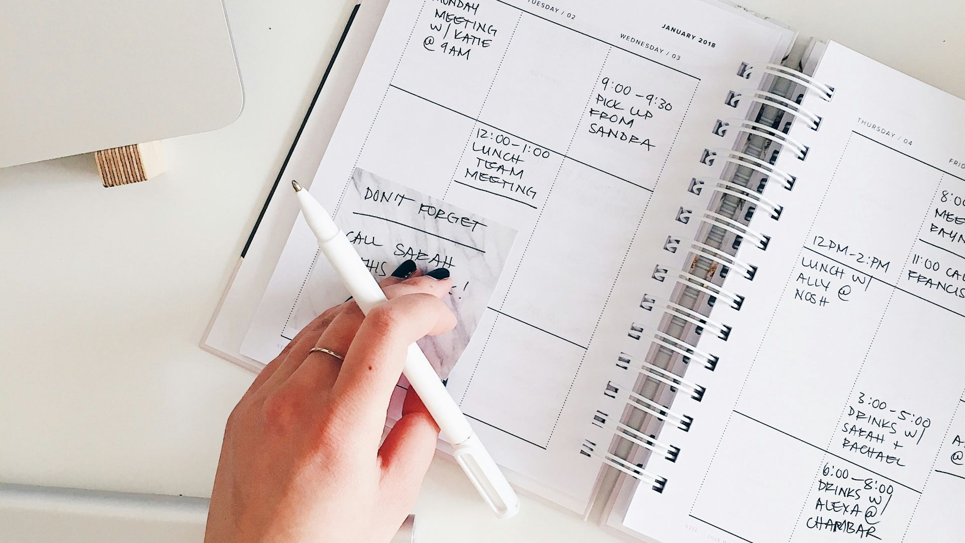 person holding notepad and pen flat lay photography