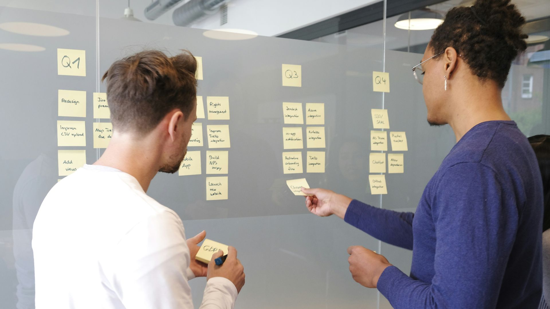 man in blue long sleeve shirt holding smartphone