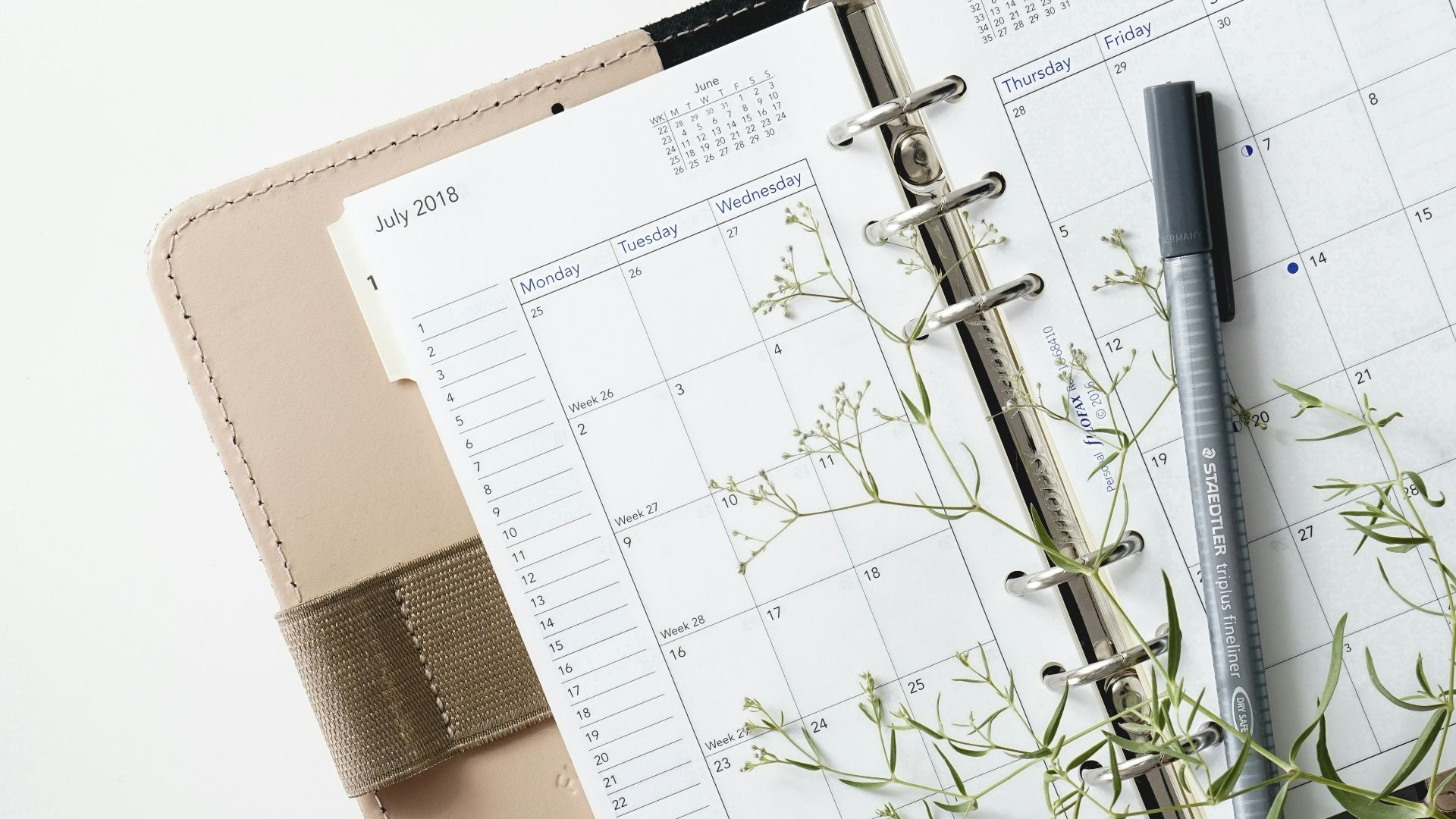 grey and black pen on calendar book