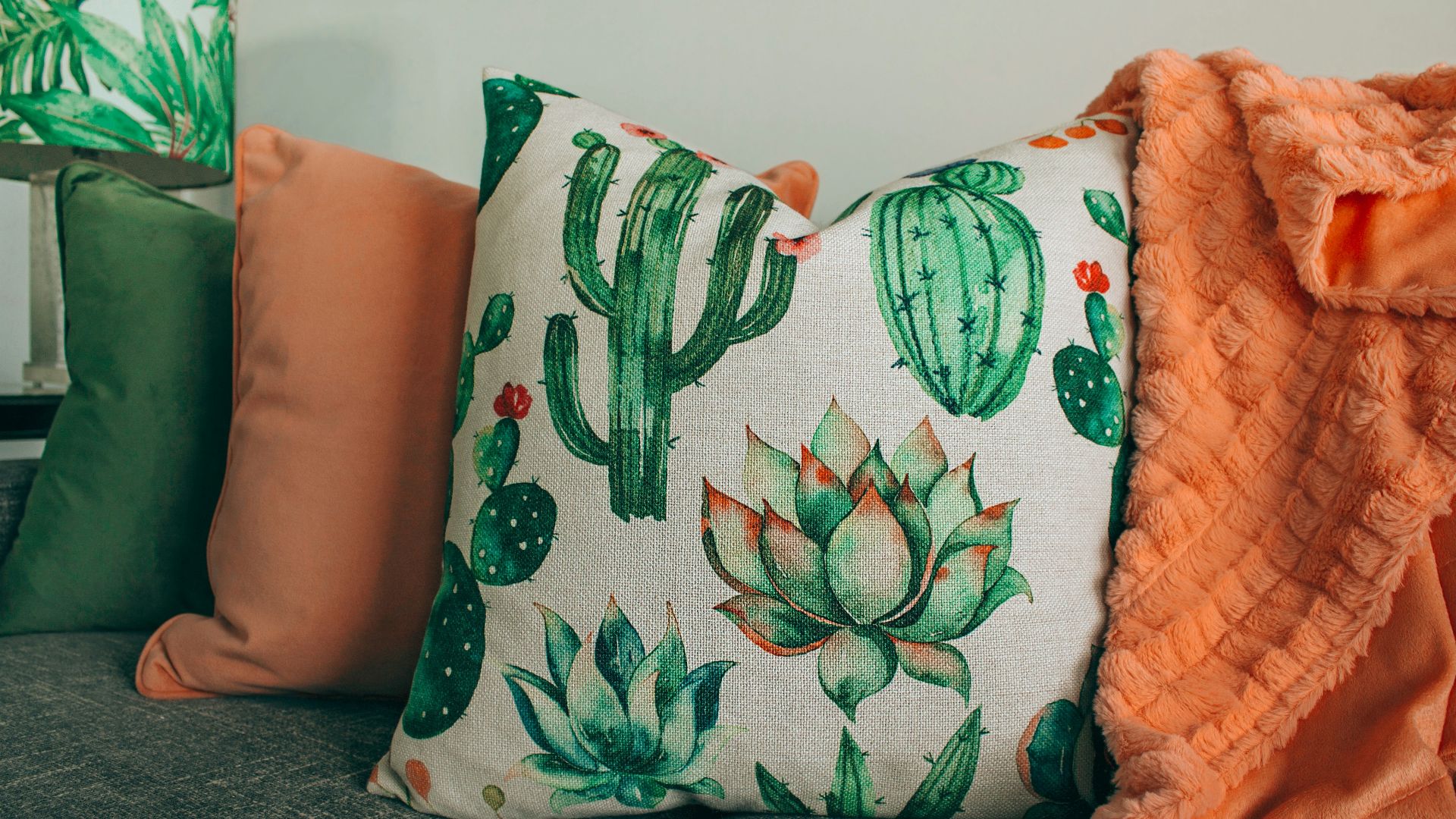 three green, orange, and white throw pillows on sofa