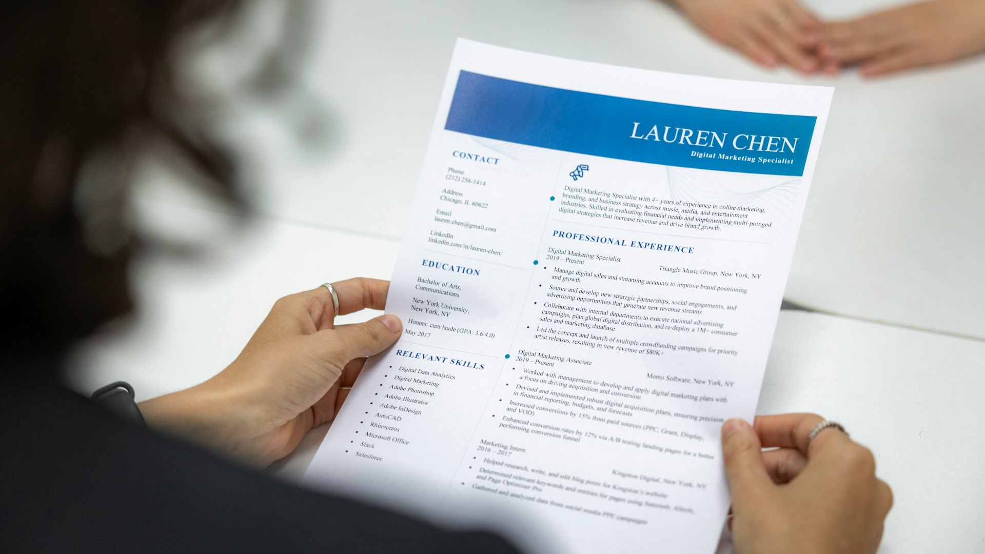 a woman is reading a resume at a table