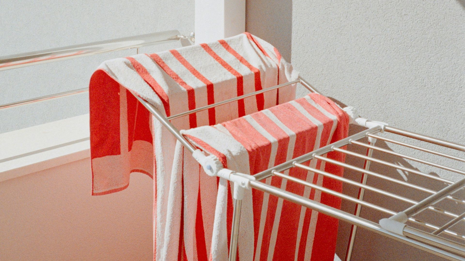 two red and white striped towels are on a wire rack