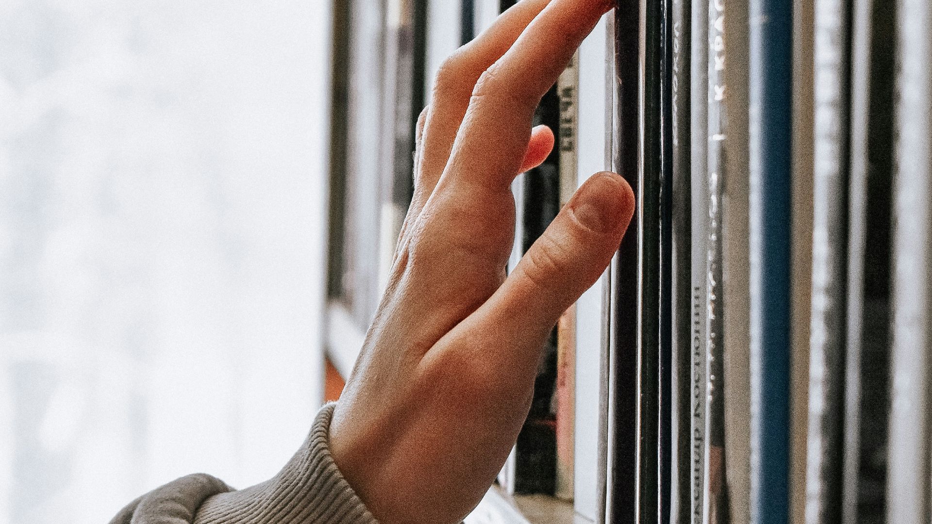 person in white long sleeve shirt holding white book