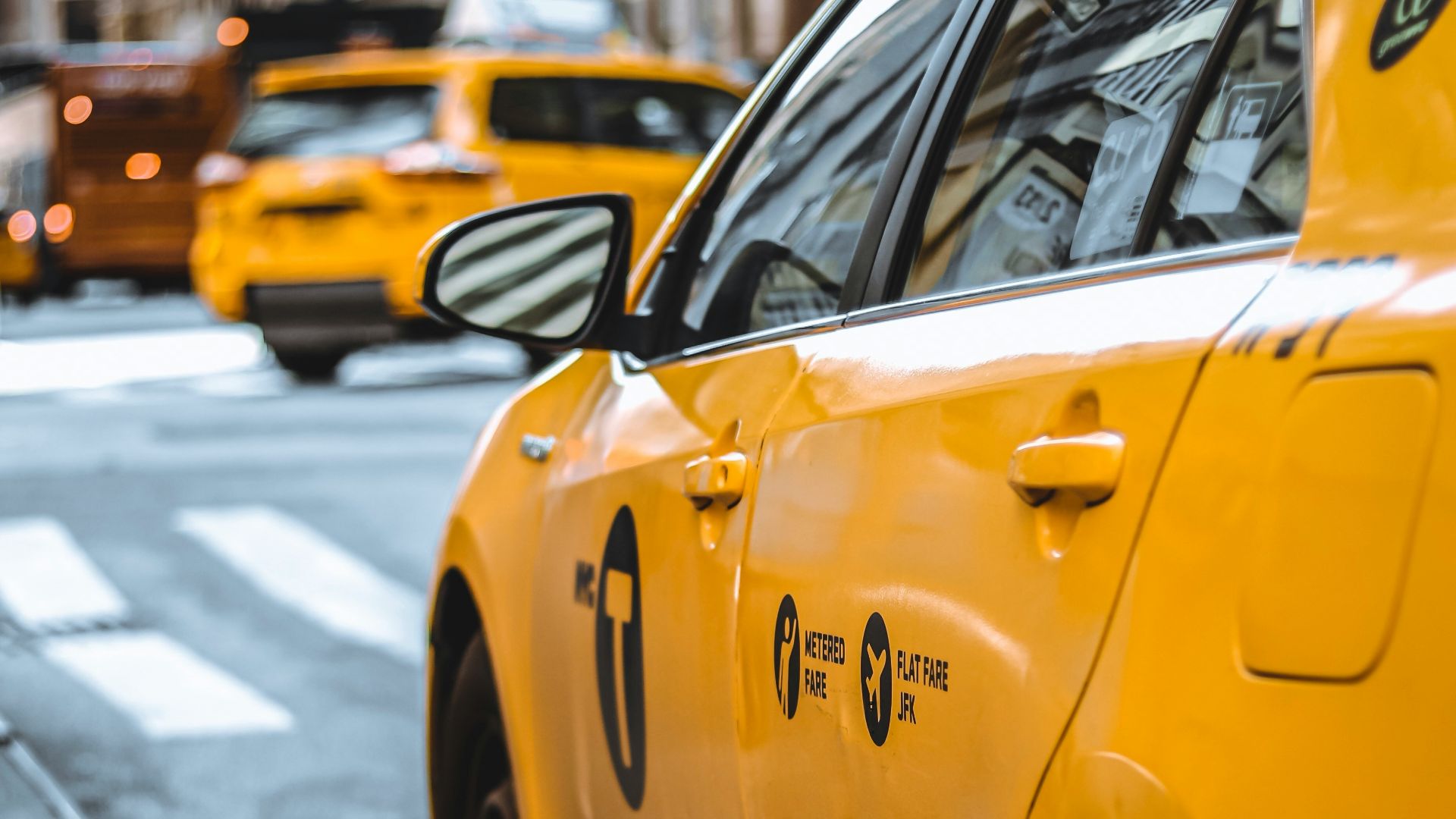 yellow taxi parked beside curb