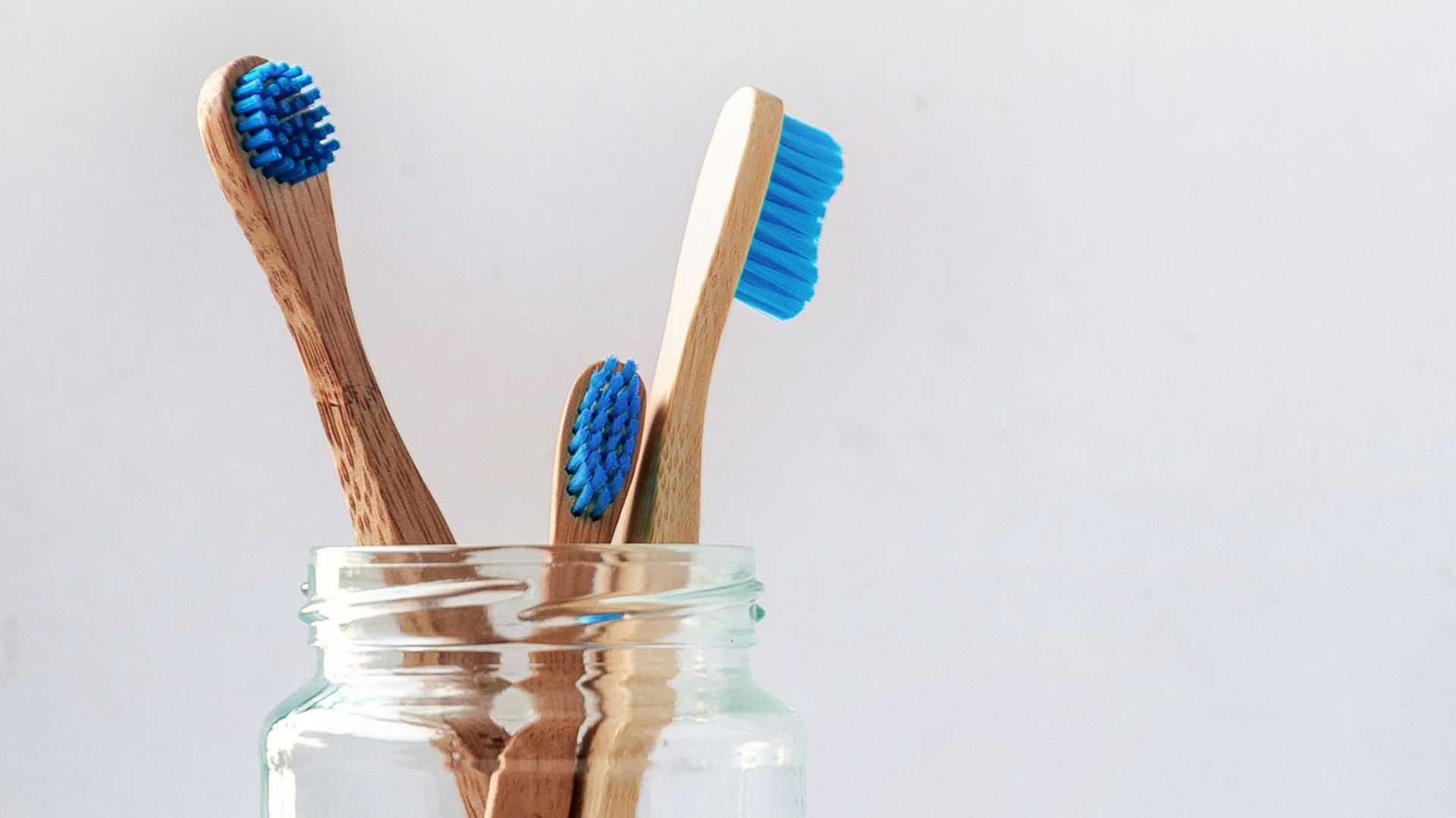 blue and white toothbrush in clear glass jar