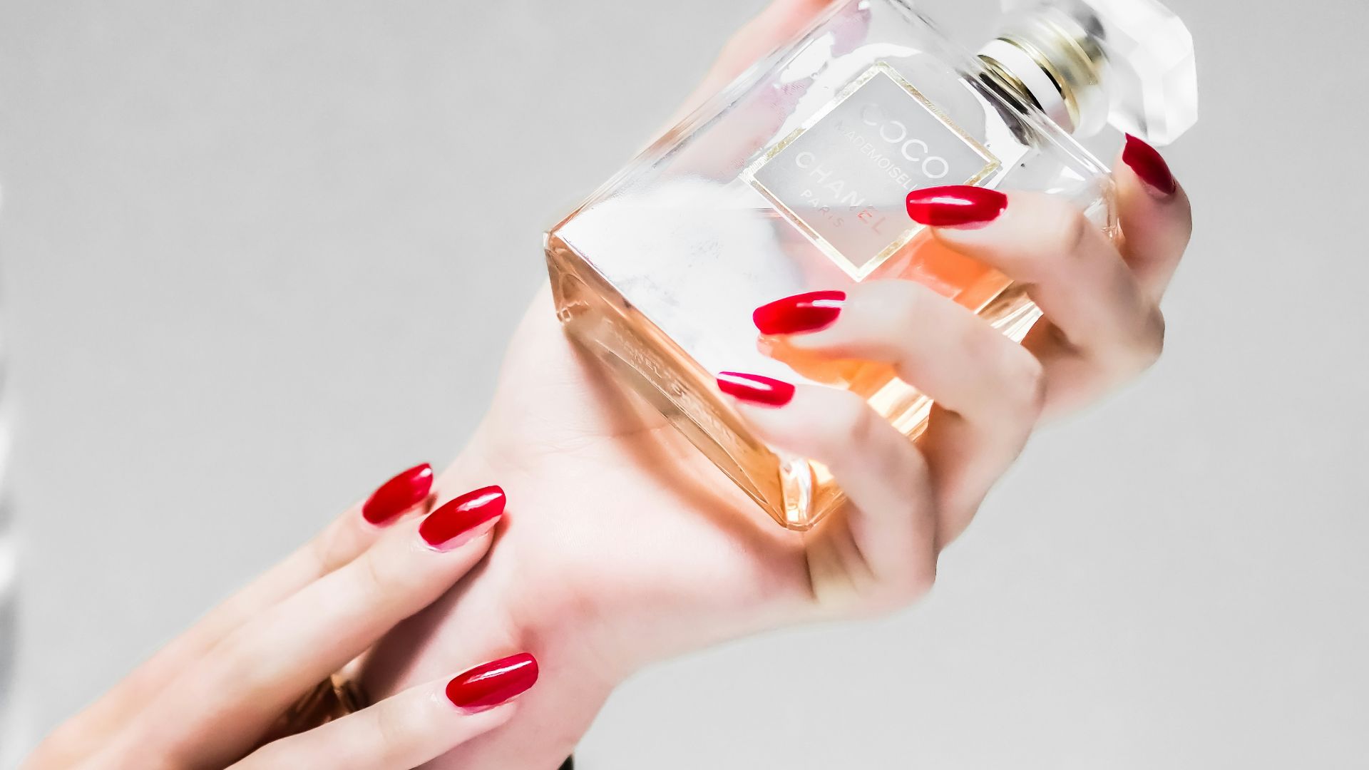 person holding clear glass bottle