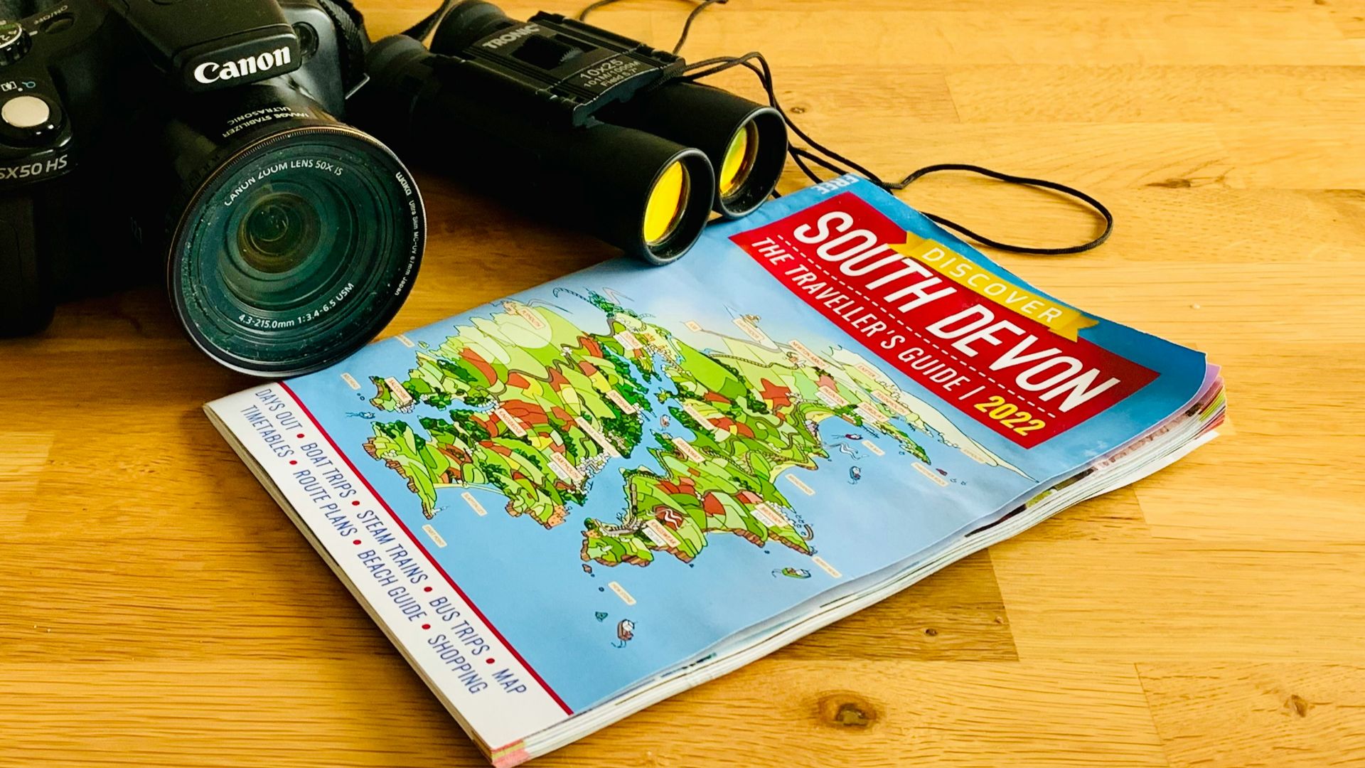 a camera sitting on top of a wooden floor next to a book