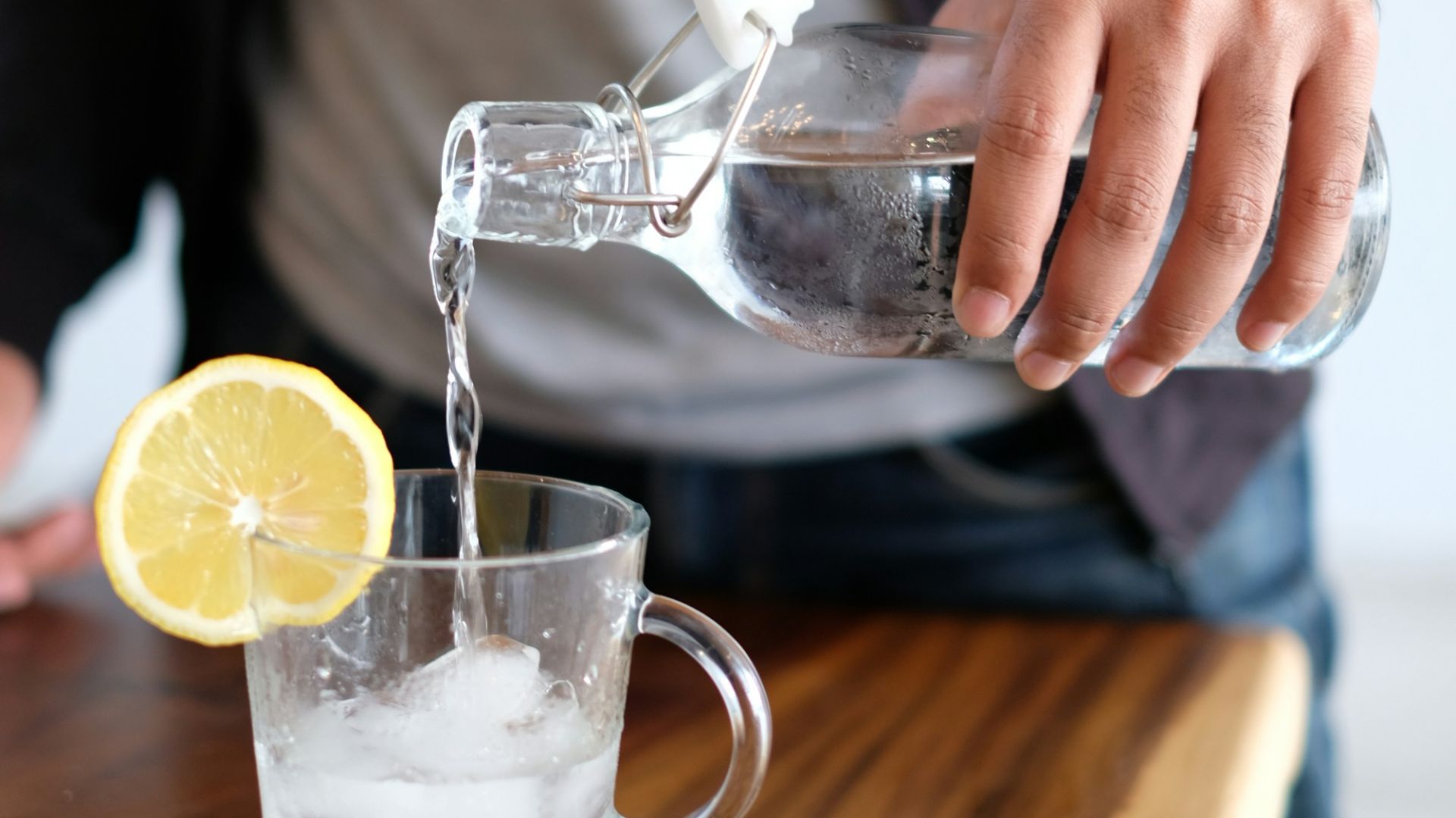 man pouring water in glass