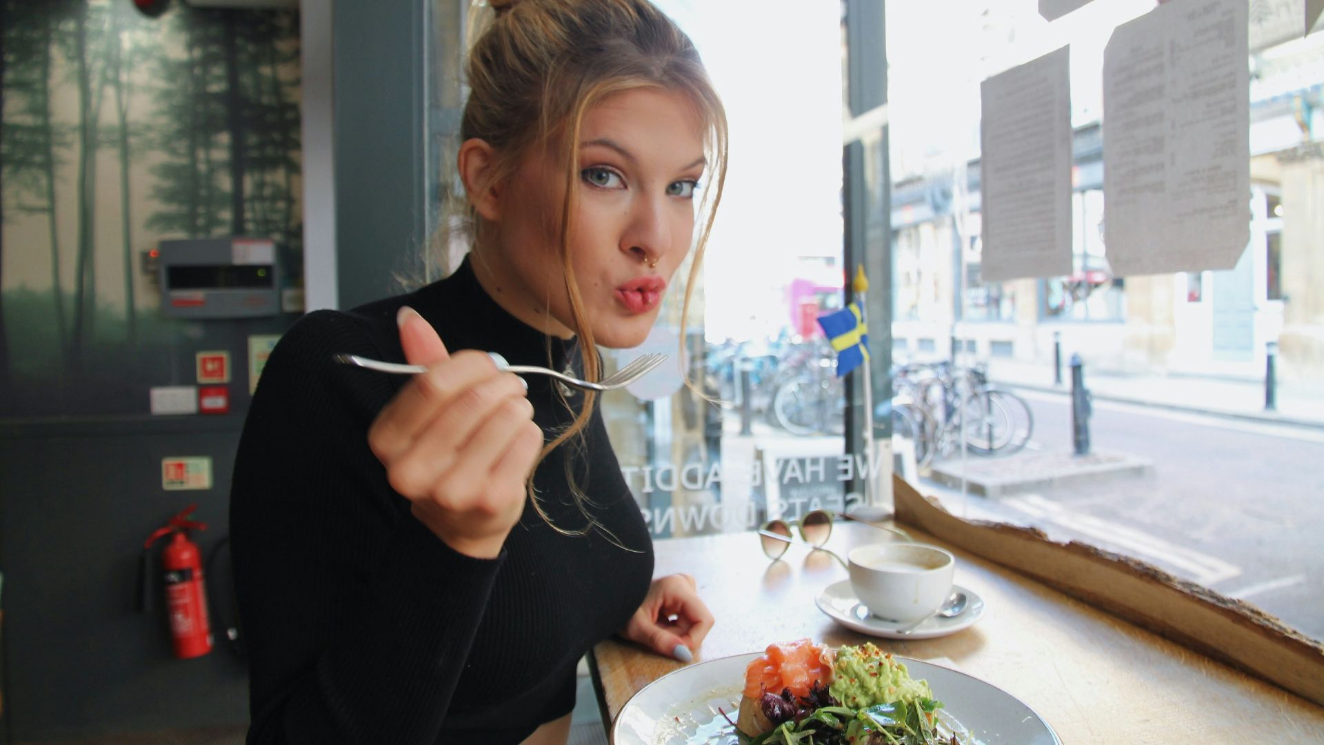 woman in black long sleeve shirt eating