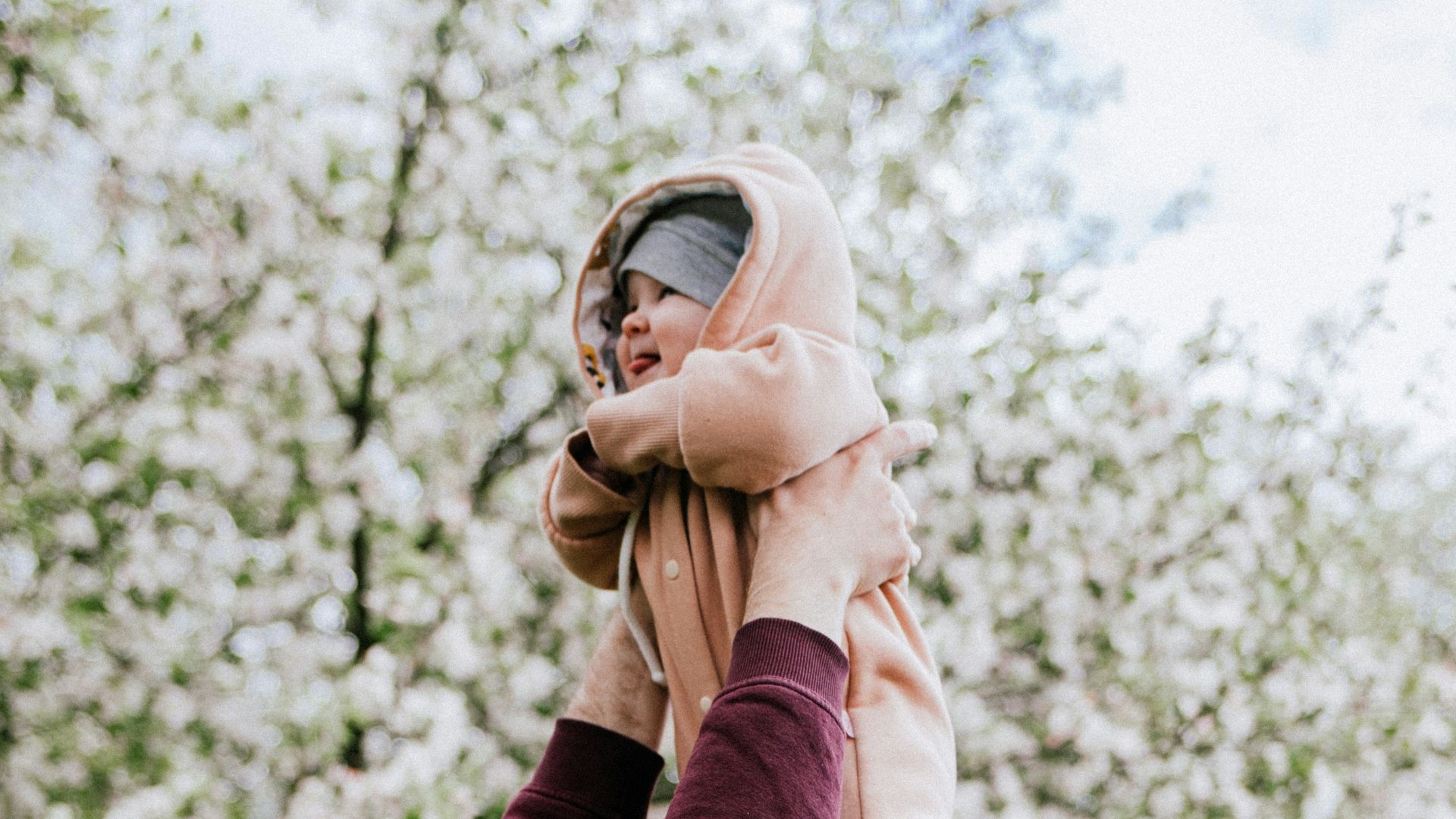 a man holding a baby up in the air