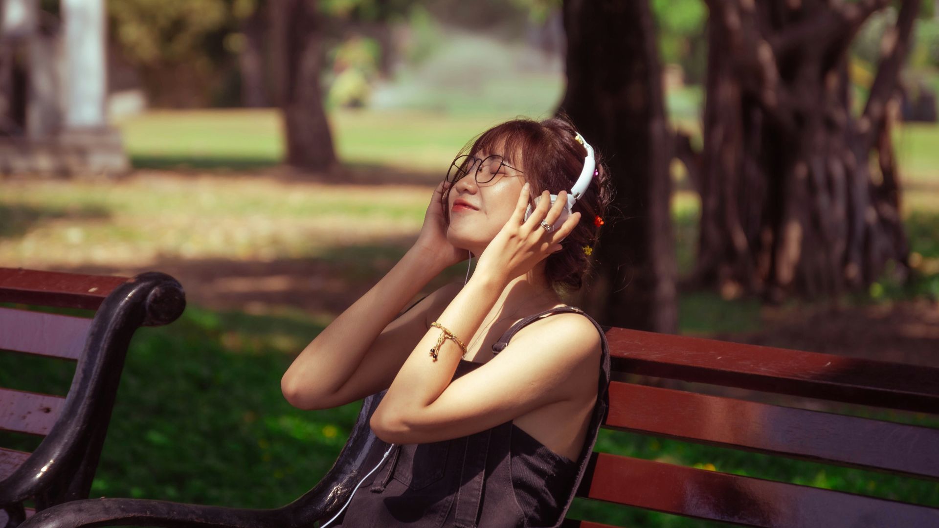 a woman sitting on a bench talking on a cell phone