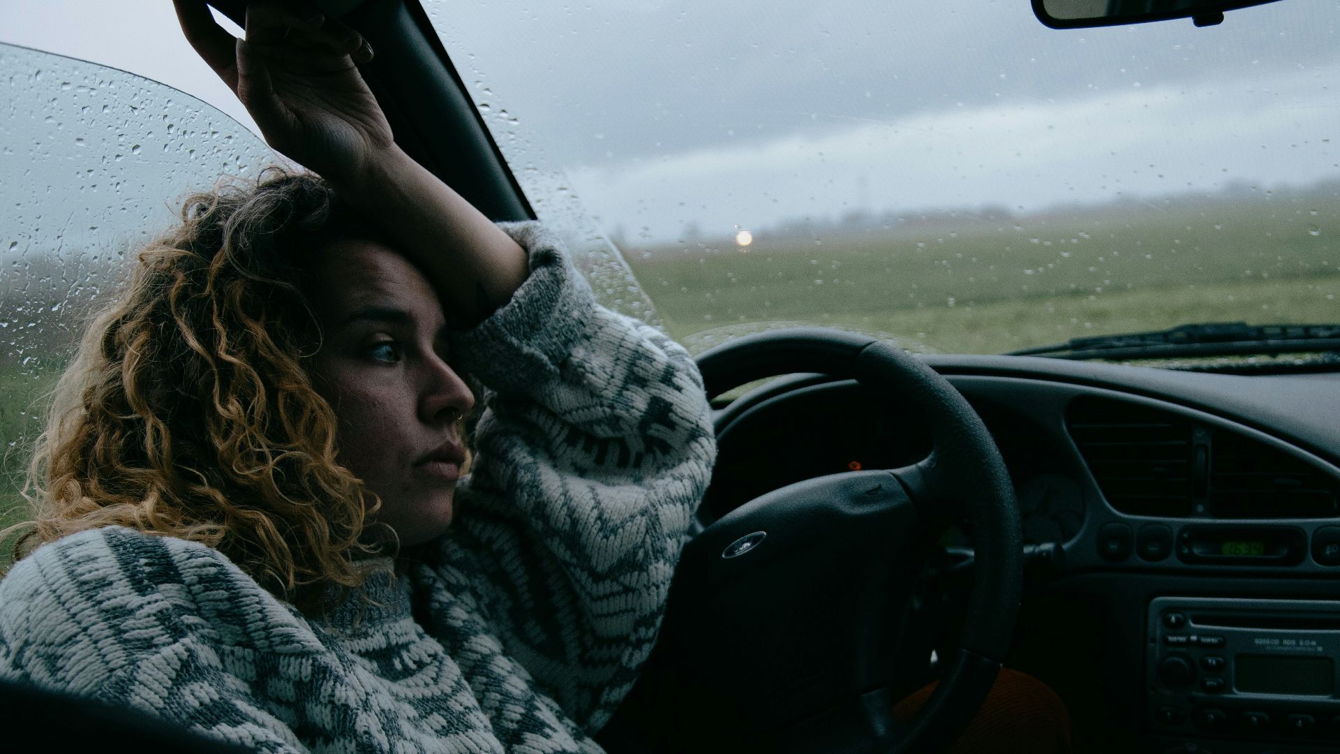 woman in black and white scarf driving car