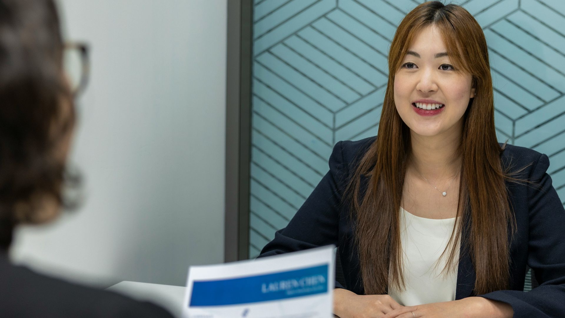 a woman sitting at a table with a piece of paper in front of her