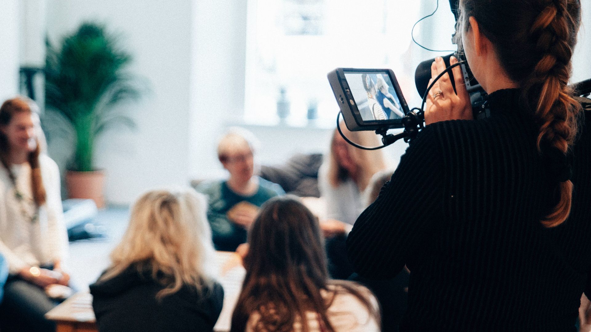 woman holding camera standing near people